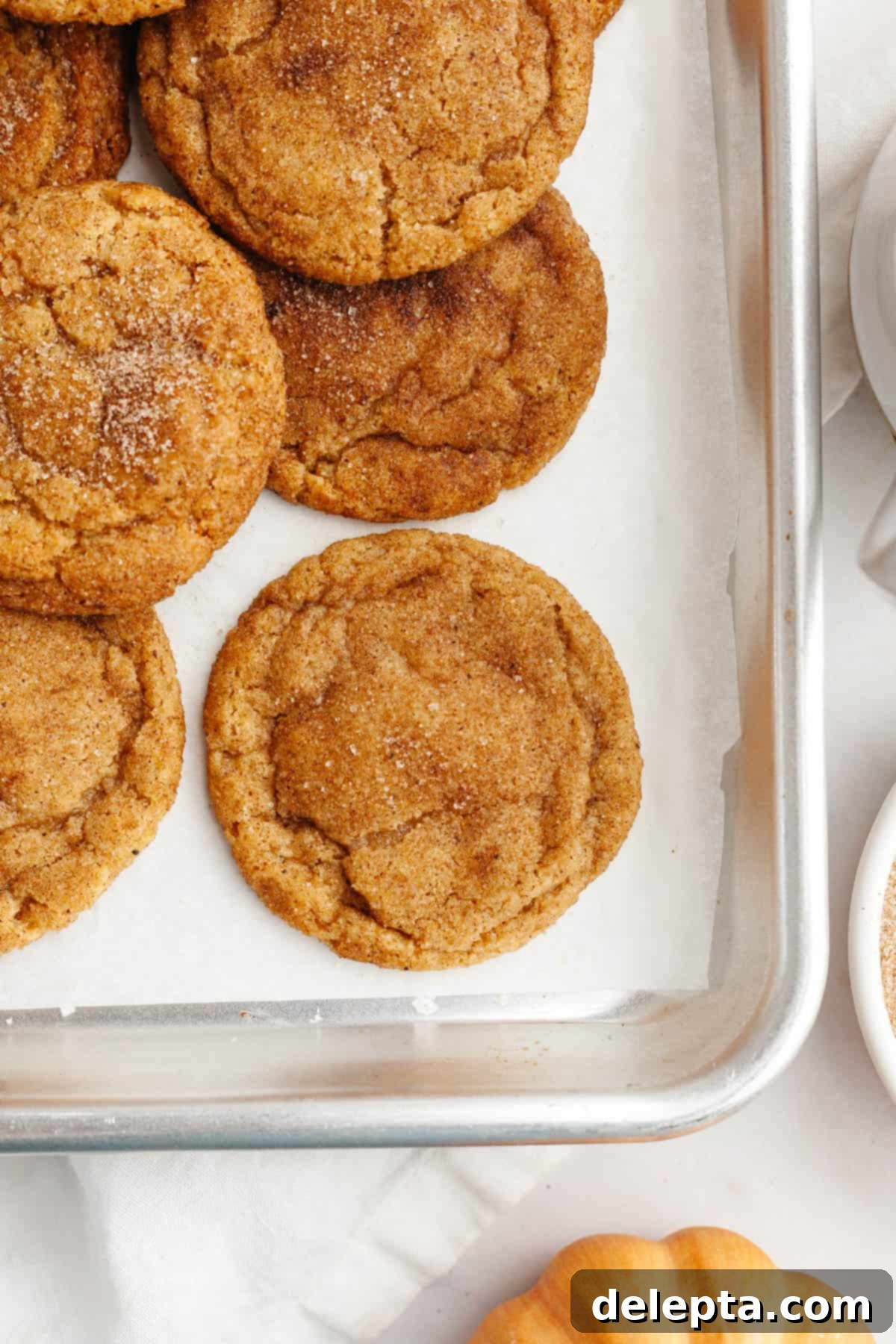 Ultimate Soft and Chewy Pumpkin Cookies 10 A tray of freshly baked, chewy pumpkin cookies cooling on a baking sheet.