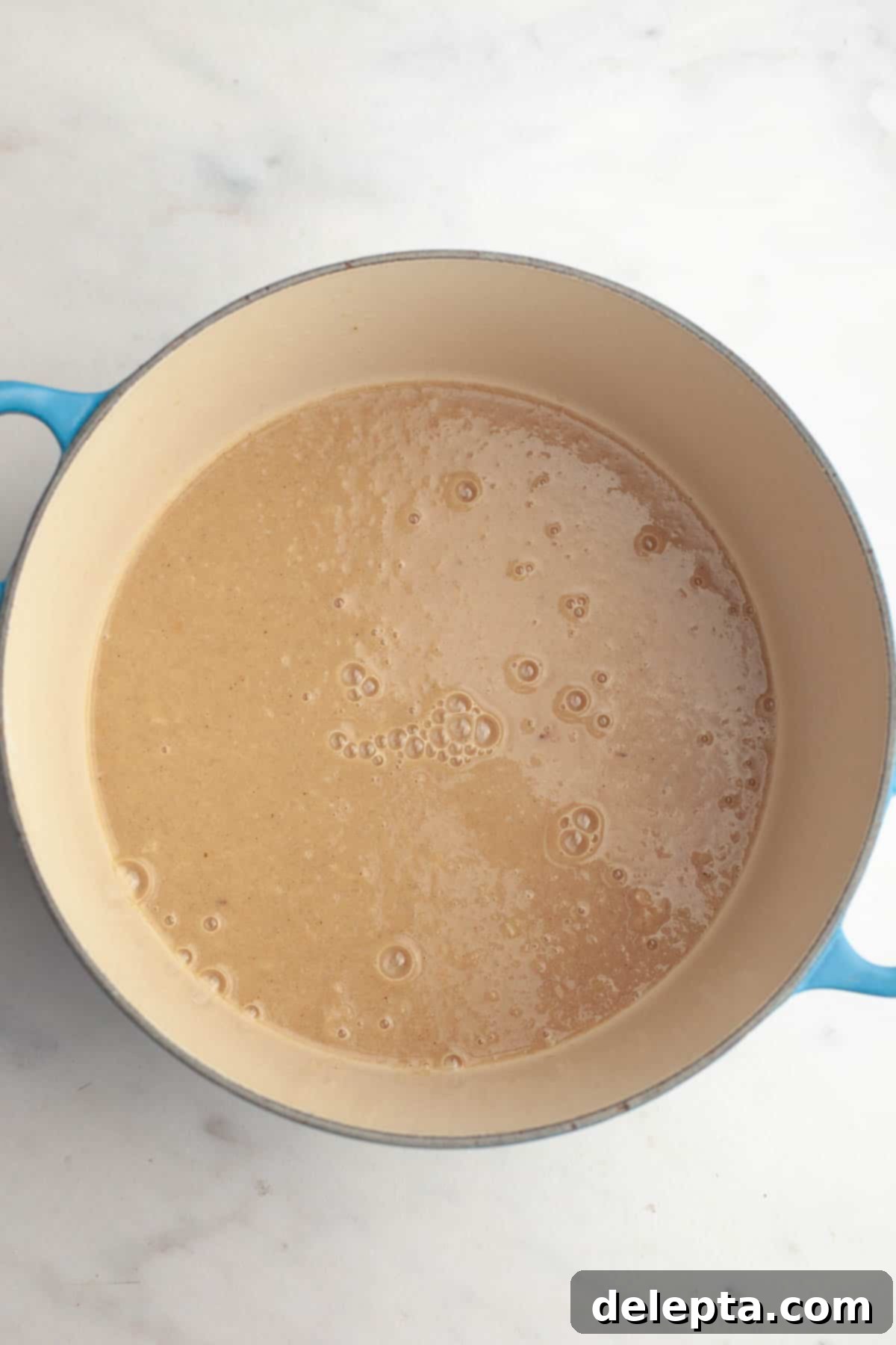Warm Roasted Butternut & Carrot Ginger Soup 8 A large stock pot with a beige colored soup.