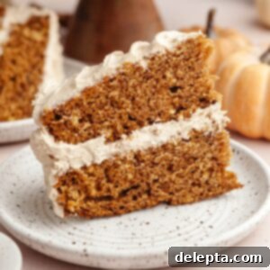 Pumpkin Spiced Latte Cake Bake 12 A delightful slice of pumpkin spice latte cake, featuring its moist layers and creamy frosting, perfectly presented on a plate.