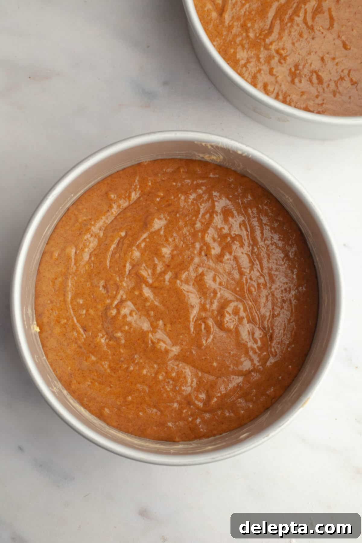Pumpkin Spiced Latte Cake Bake 6 Two cake pans filled evenly with unbaked pumpkin cake batter, ready for the oven.