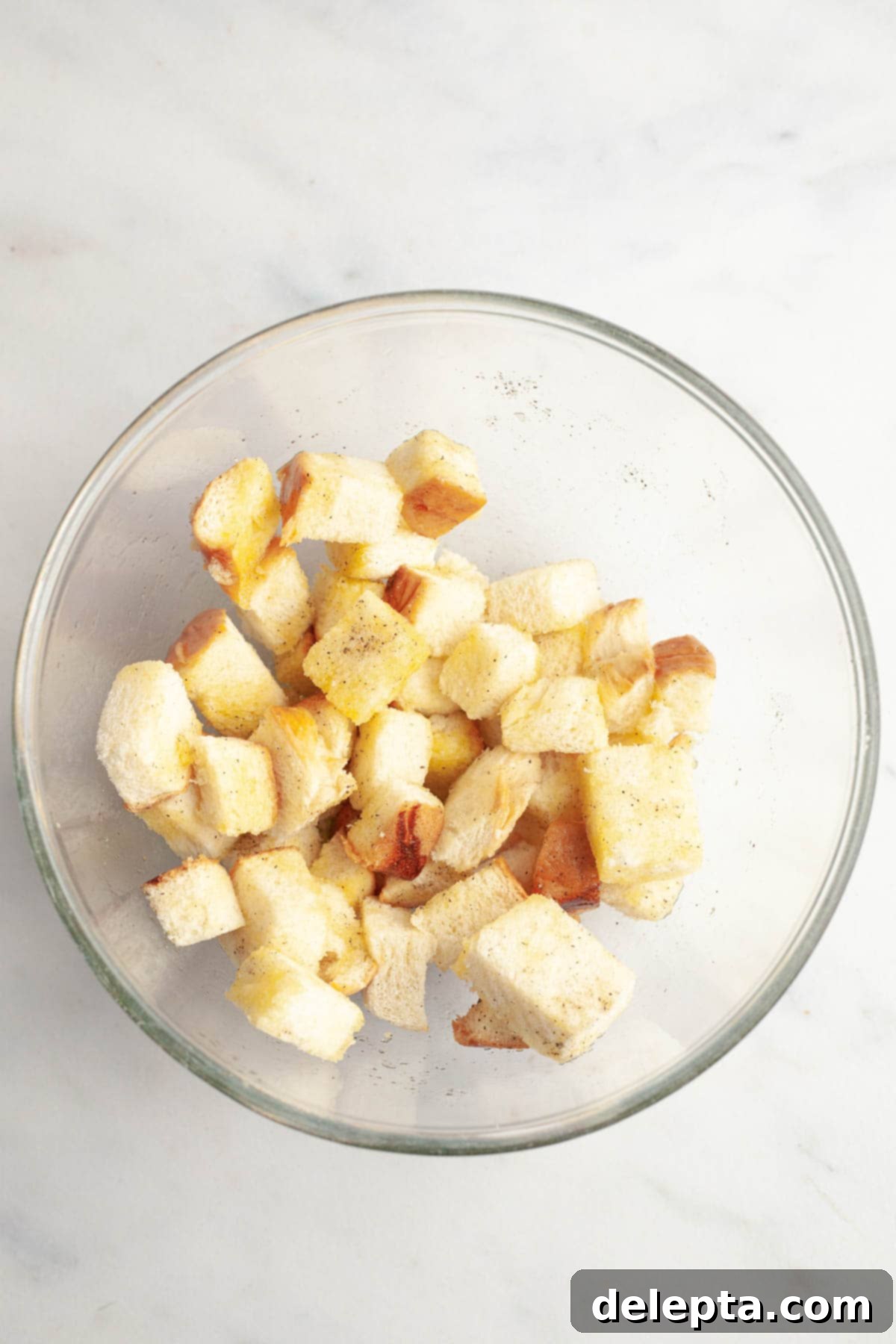 Whip Up Perfect Brioche Croutons at Home 4 Cubed brioche bread neatly arranged in a clear glass bowl, ready for seasoning.