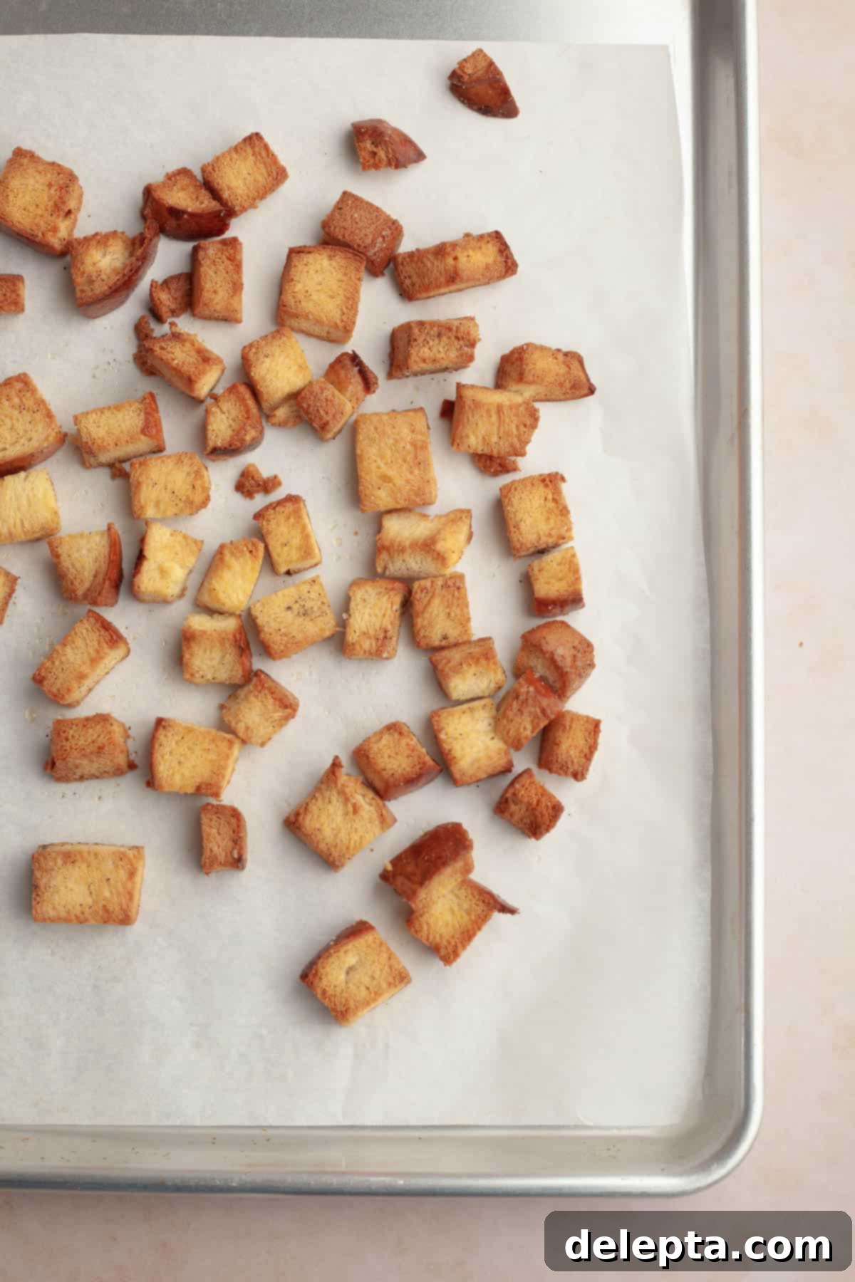 Whip Up Perfect Brioche Croutons at Home 6 Freshly baked brioche croutons, perfectly golden brown, cooling on a baking sheet directly out of the oven.