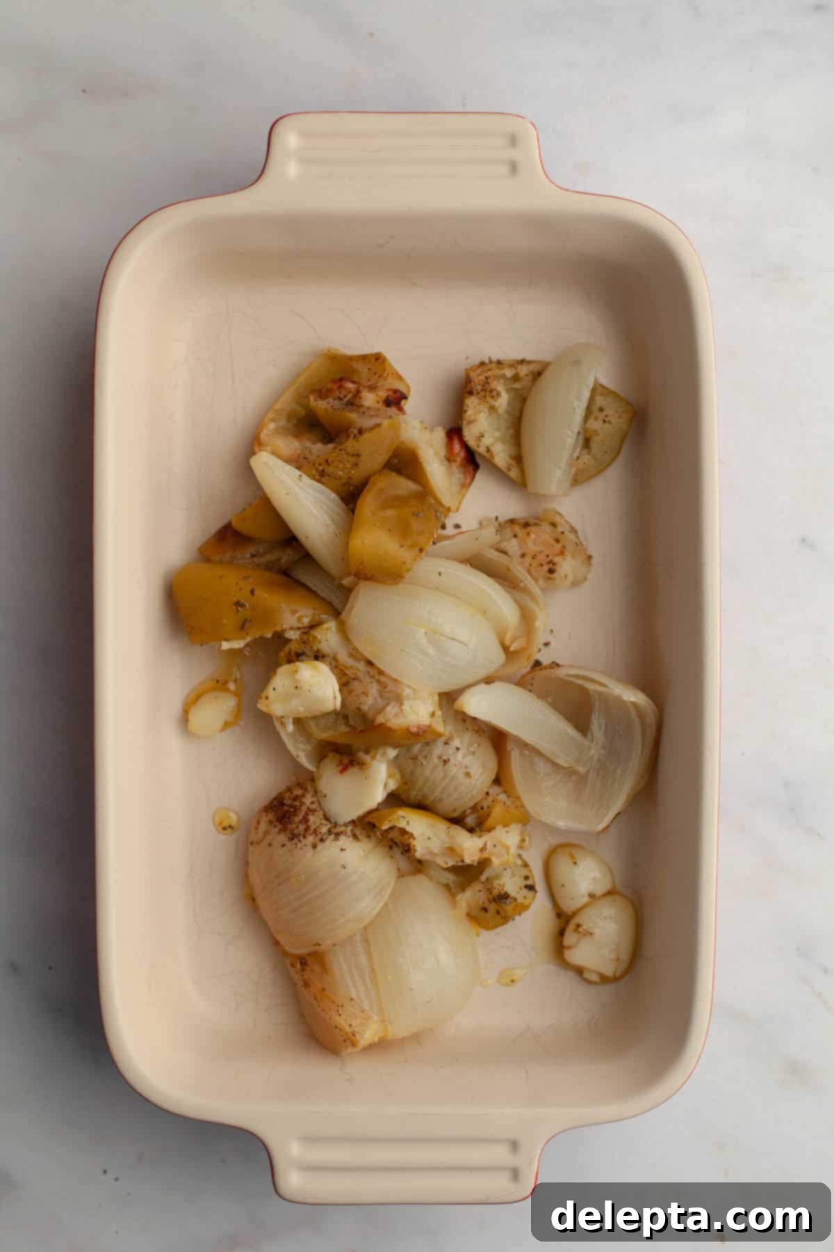 Autumn Gold Roasted Butternut Chicken Soup 6 A small baking dish with roasted onions, garlic, and apples, removed early from the sheet pan to prevent over-browning.