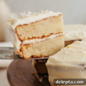 Brown Butter Cream Cheese Cardamom Cake 11 A silver serving knife lifting up a slice of cardamom cake, showcasing its beautiful layers.