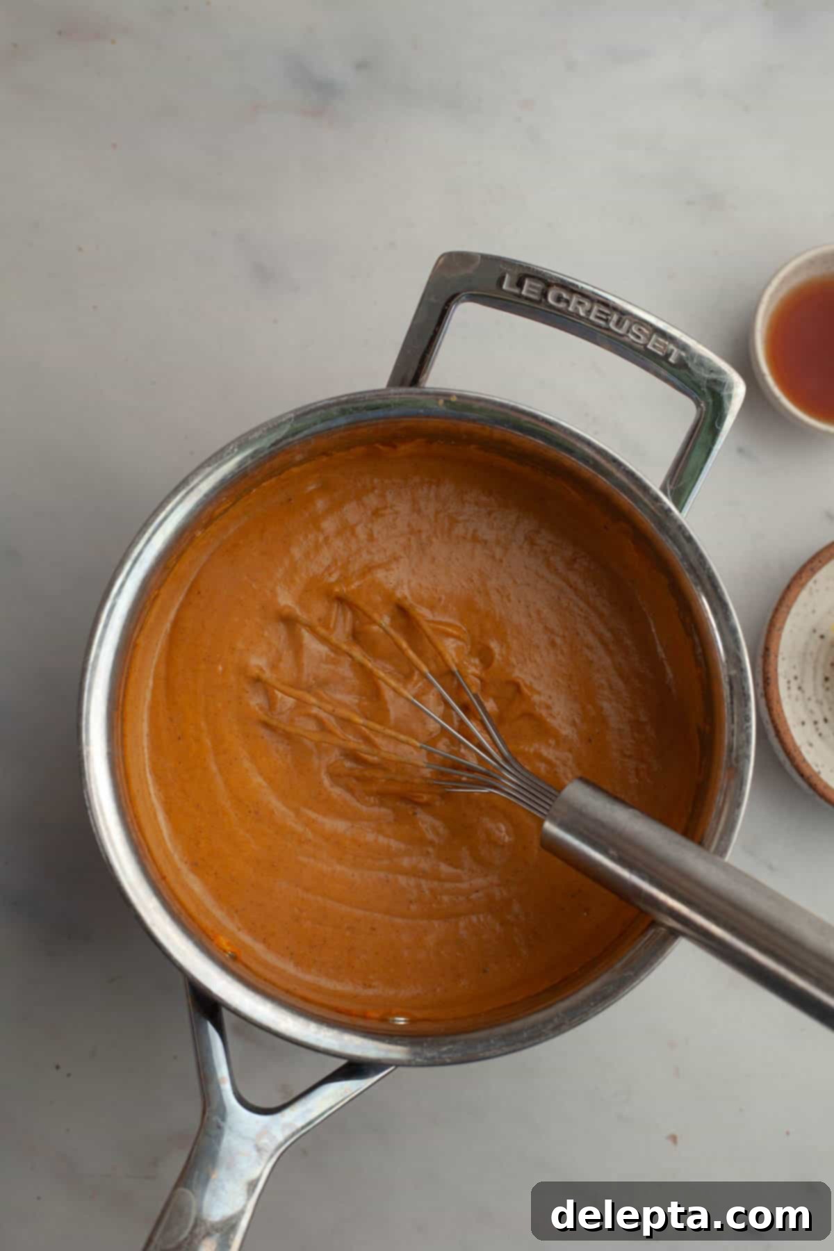 Effortless No Bake Pumpkin Delights 6 Pumpkin pudding in a saucepan being continuously whisked over a medium heat as it thickens.