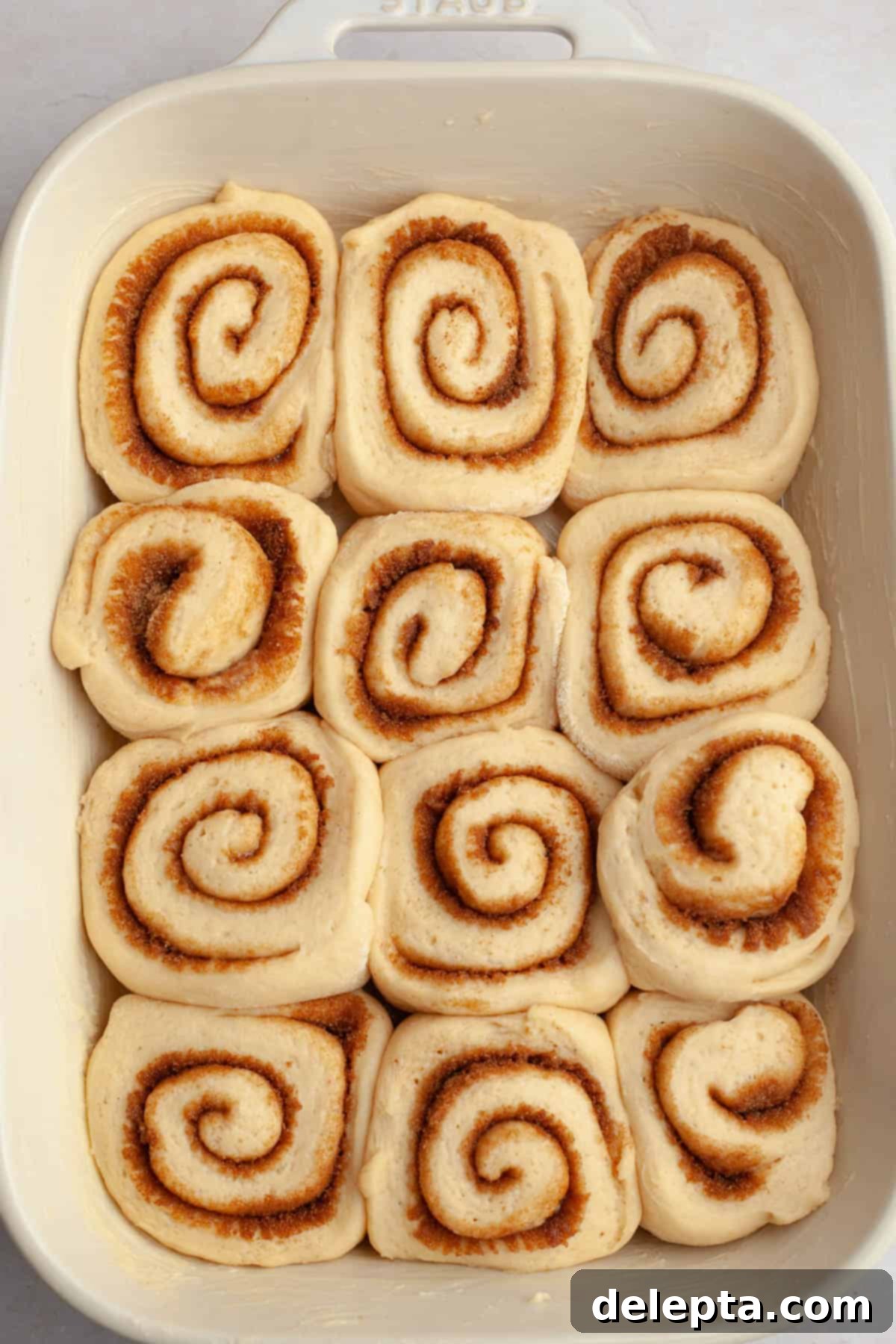 Rich Brown Butter Cinnamon Rolls with Velvety Brown Butter Frosting 11 Unbaked brown butter cinnamon rolls in a white baking dish.