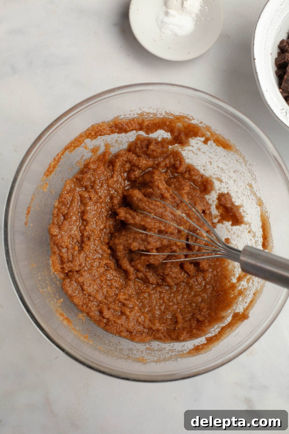 Decadent Espresso Infused Brown Butter Chocolate Cookies 5 Cookie dough in a glass bowl with a whisk.