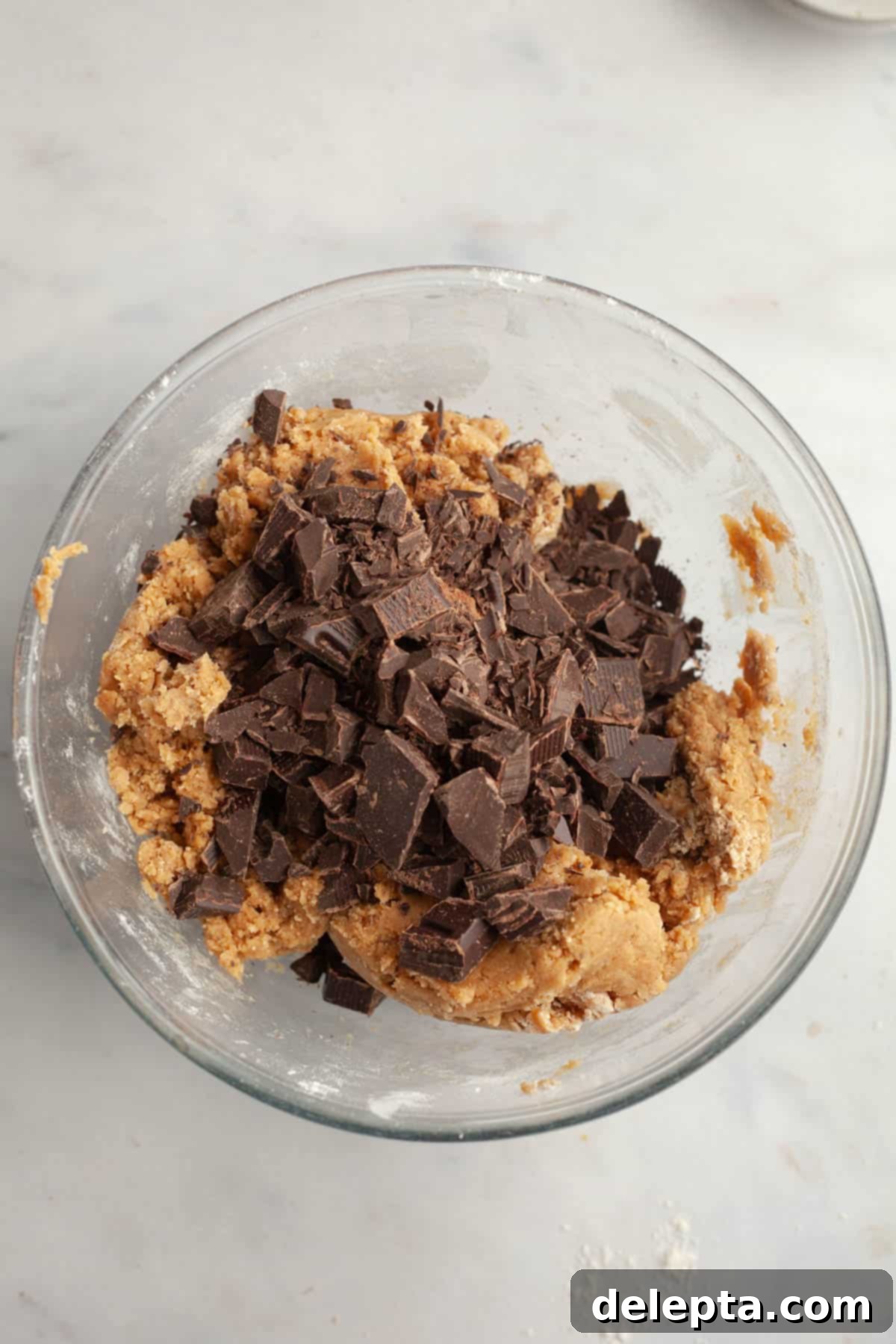 Decadent Espresso Infused Brown Butter Chocolate Cookies 8 A glass bowl with cookie dough and chocolate chunks.