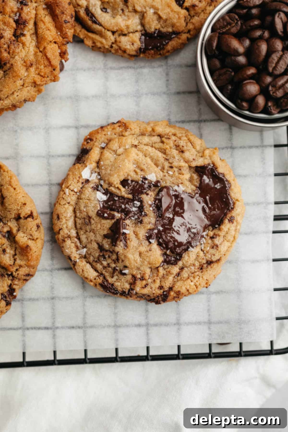 Decadent Espresso Infused Brown Butter Chocolate Cookies 10 Brown butter chocolate chip espresso cookies, sprinkled with some flaky sea salt on parchment paper.