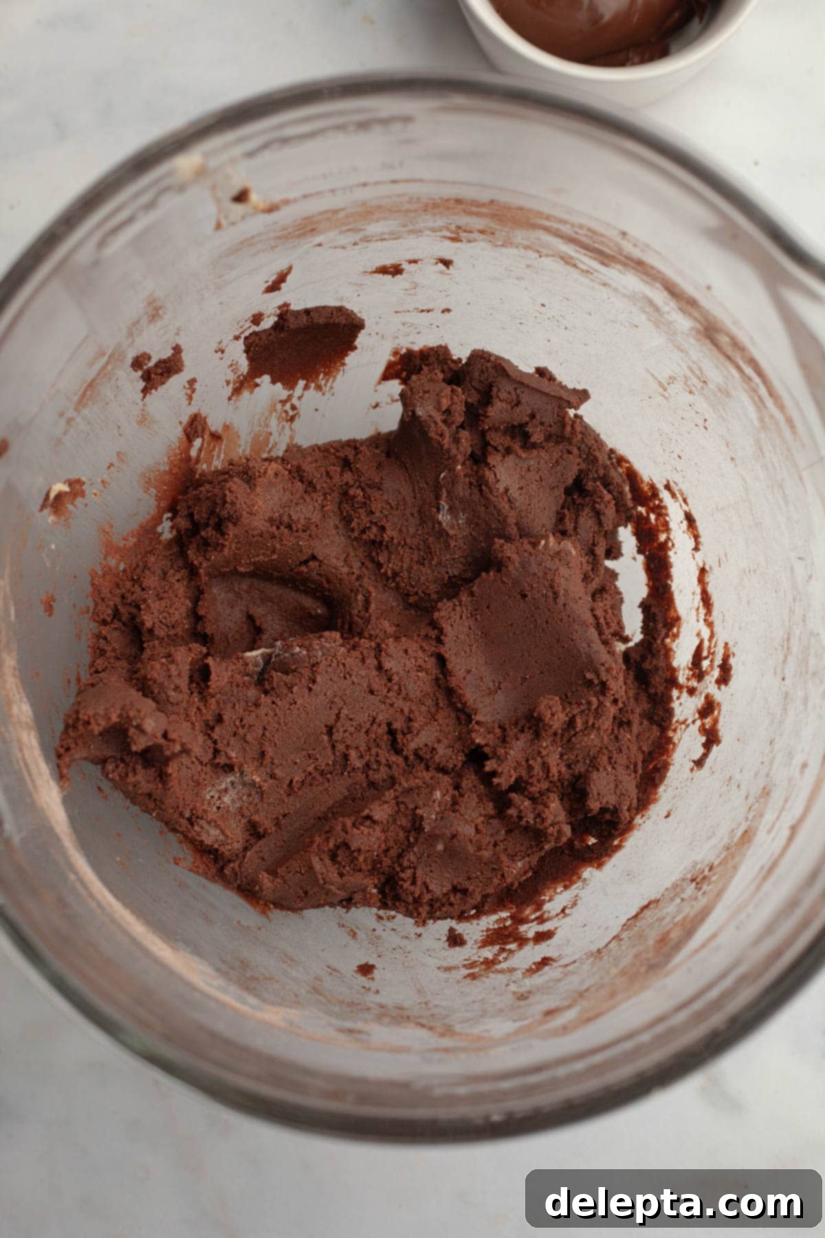 Double Nutella Bliss: Easy Thumbprint Cookies with Ganache 7 A mixing bowl with rich chocolate cookie dough, just combined.