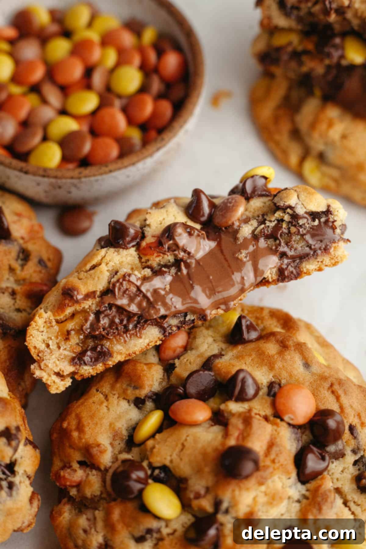 Decadent Peanut Butter Nutella Stuffed Chocolate Chip Cookies 13 A close up of Nutella peanut butter cookies, one is cut in half showing it is stuffed with molten Nutella.