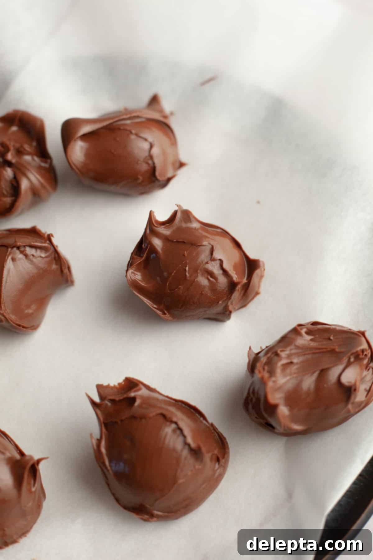 Decadent Peanut Butter Nutella Stuffed Chocolate Chip Cookies 4 Nutella scooped out onto parchment paper, ready for freezing.
