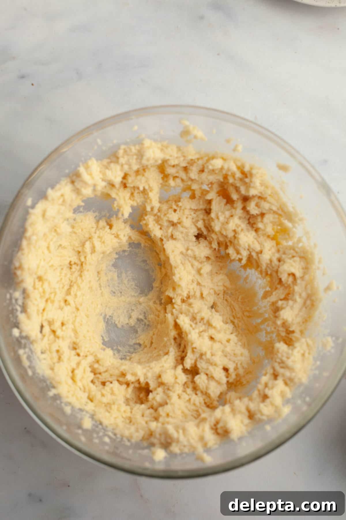 Peanut Butter Snickerdoodle Bliss 5 Creamy cookie dough mixture in a glass bowl, prepared with butter and sugar.