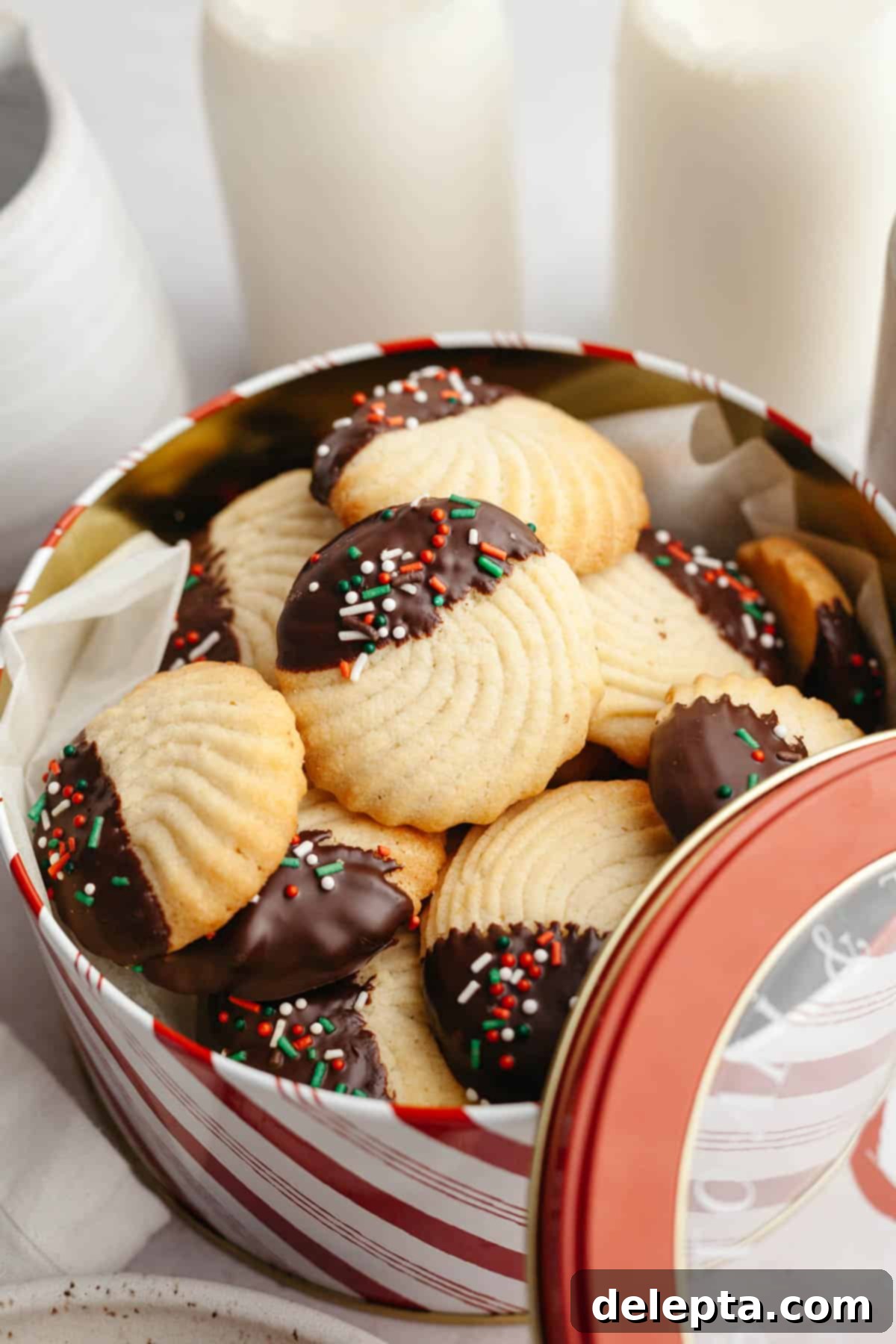 Decadent Chocolate Dipped Danish Butter Cookies 2 Chocolate dipped butter cookies with sprinkles in a tin, ready for holiday gifting or enjoyment.