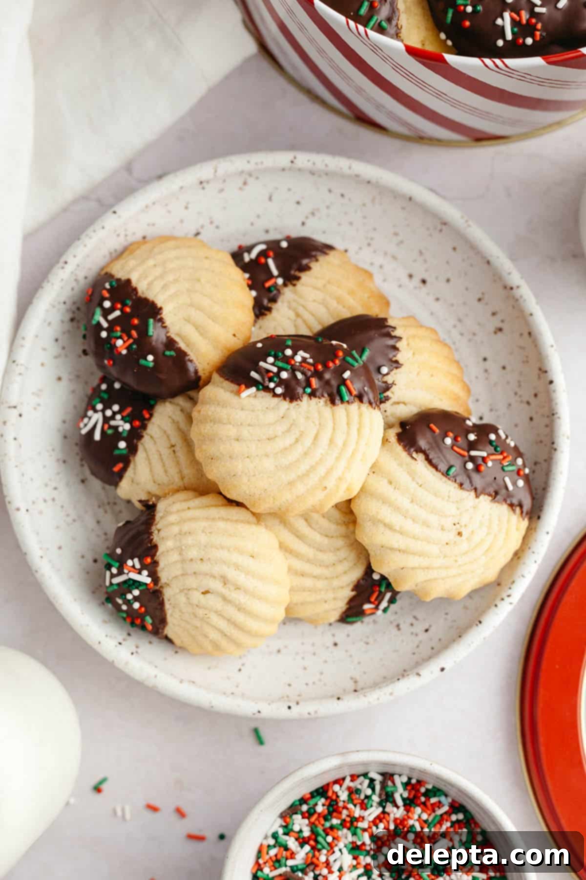 Decadent Chocolate Dipped Danish Butter Cookies 11 A small plate showcasing elegant Danish piped butter cookies, half-dipped in chocolate, and a few plain.