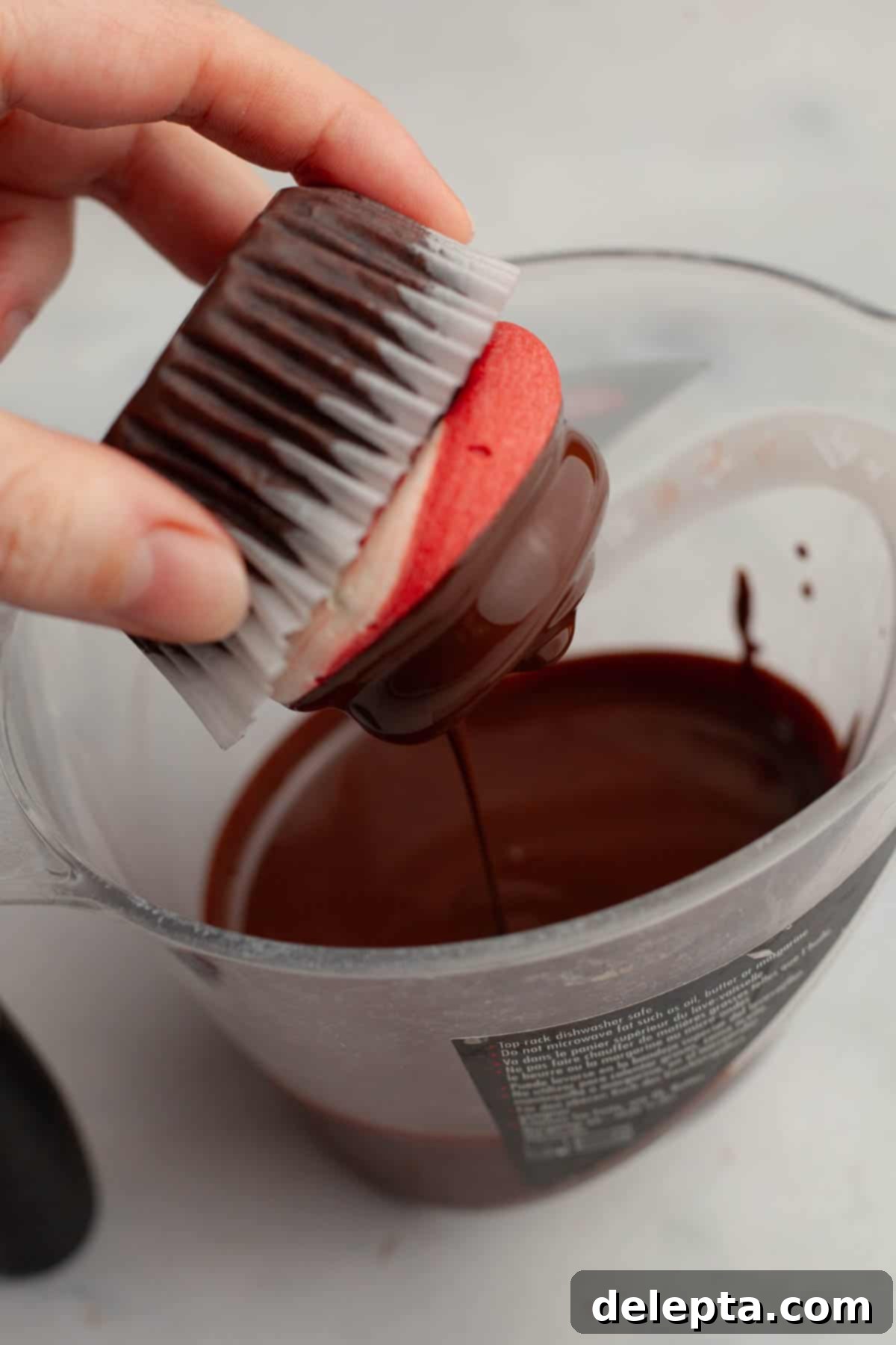 Peppermint Chocolate Dream Cupcakes 11 A hand carefully dipping a frosted chocolate peppermint cupcake into rich, melted chocolate for the magic shell.