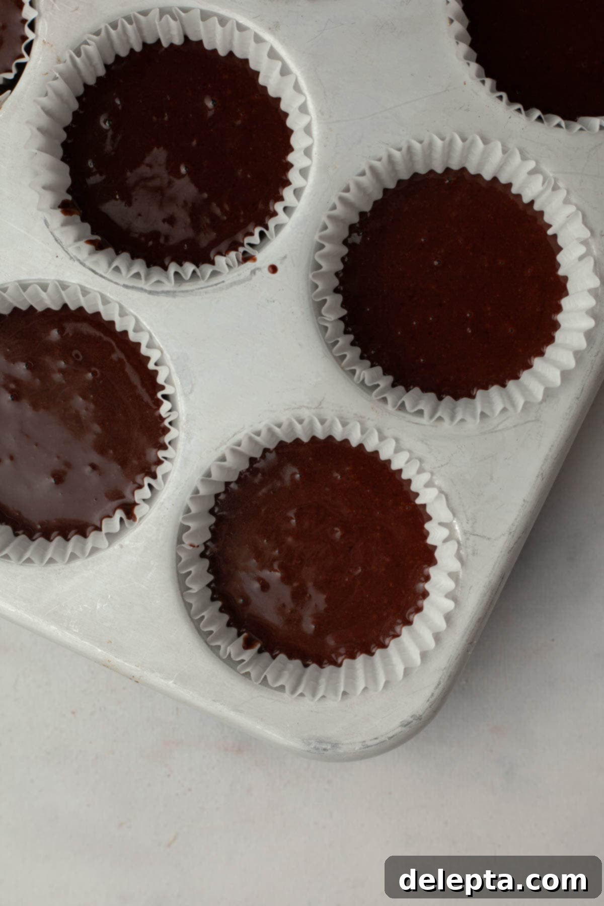Peppermint Chocolate Dream Cupcakes 7 Unbaked chocolate peppermint cupcakes perfectly lined in a cupcake tin, ready for the oven.