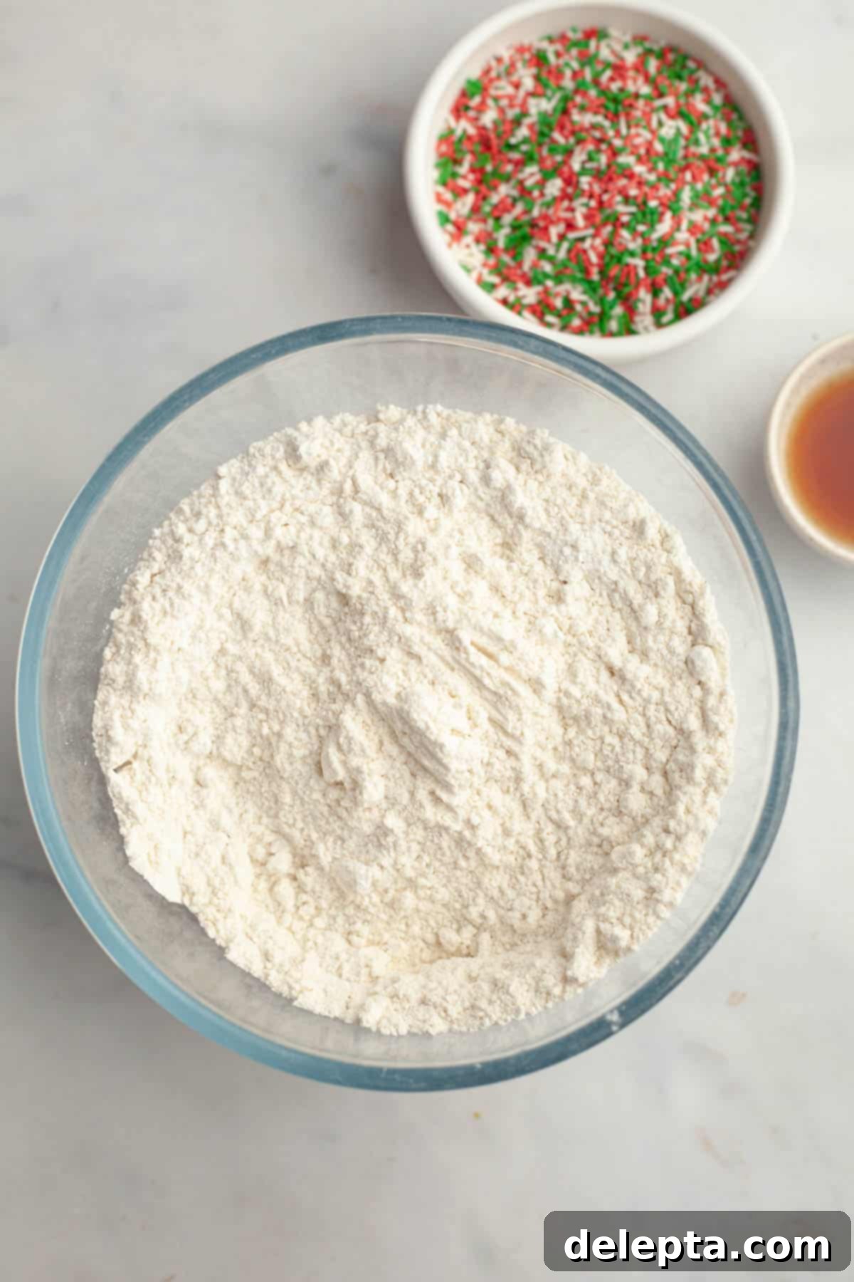 Melt-in-Your-Mouth Brown Butter Christmas Sprinkle Cookies 5 All-purpose flour in a glass bowl, ready for mixing with other dry ingredients.