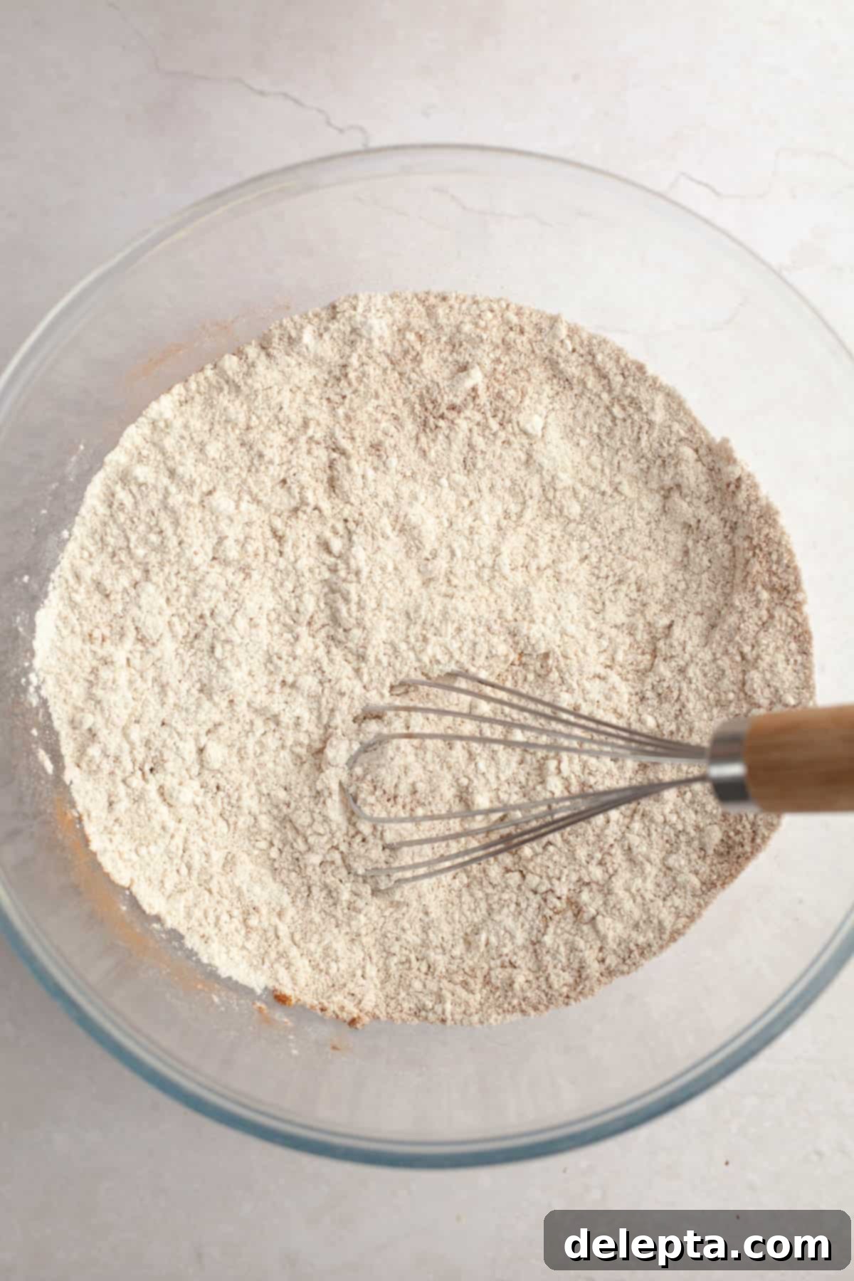 Velvet Gingerbread Cookies with Cream Cheese Frosting 5 A large glass bowl with all-purpose flour and various gingerbread spices, ready to be whisked together.
