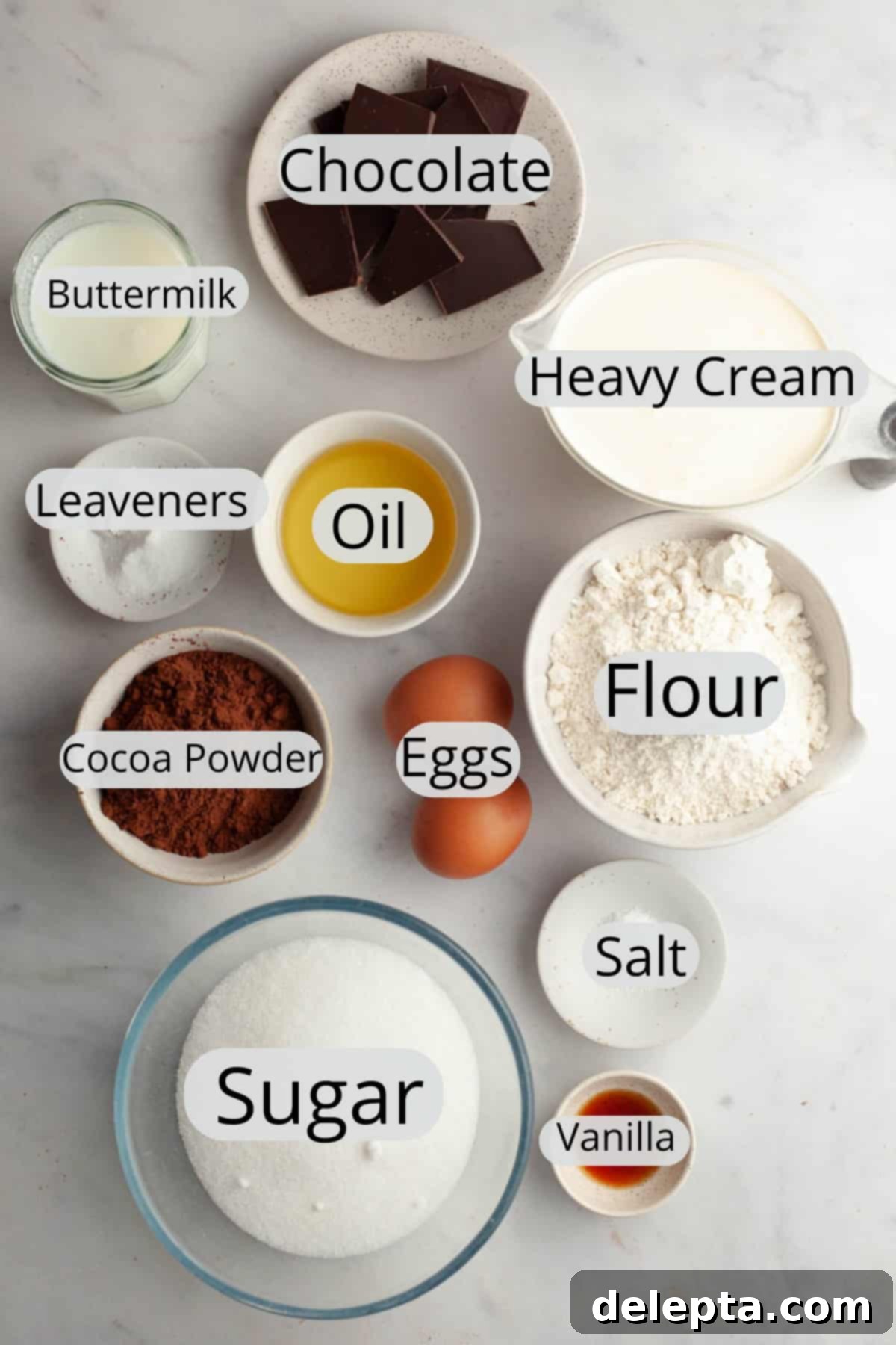 Moist and Easy Chocolate Cake with Decadent Chocolate Ganache 3 All the carefully measured ingredients for making a decadent chocolate cake with chocolate ganache, neatly arranged in individual small bowls on a rustic wooden surface, ready for baking.