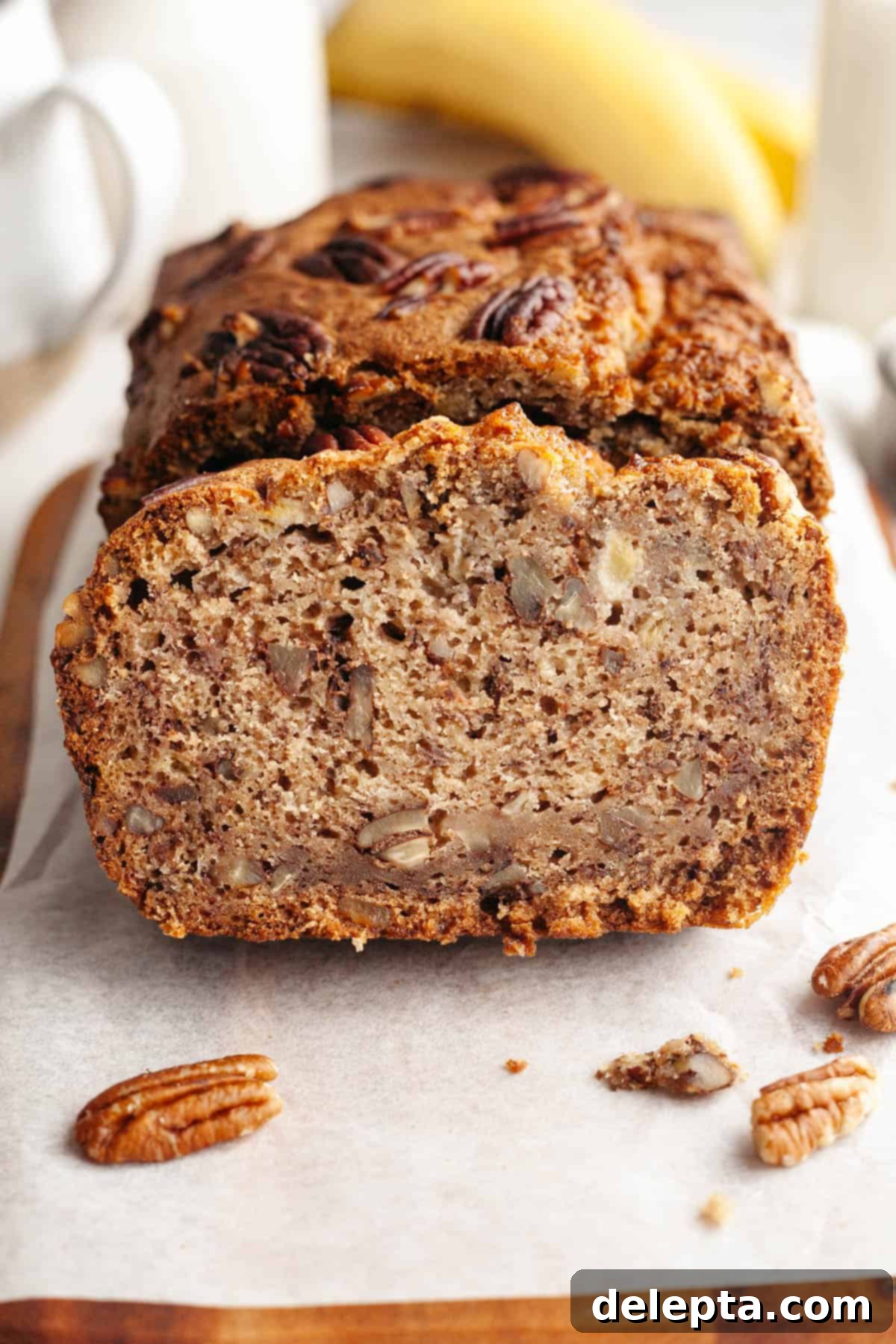 Decadent Brown Butter Cinnamon Pecan Banana Bread 2 A perfectly baked loaf of brown butter cinnamon pecan banana bread, sliced and showing its moist interior and generous pecan distribution.