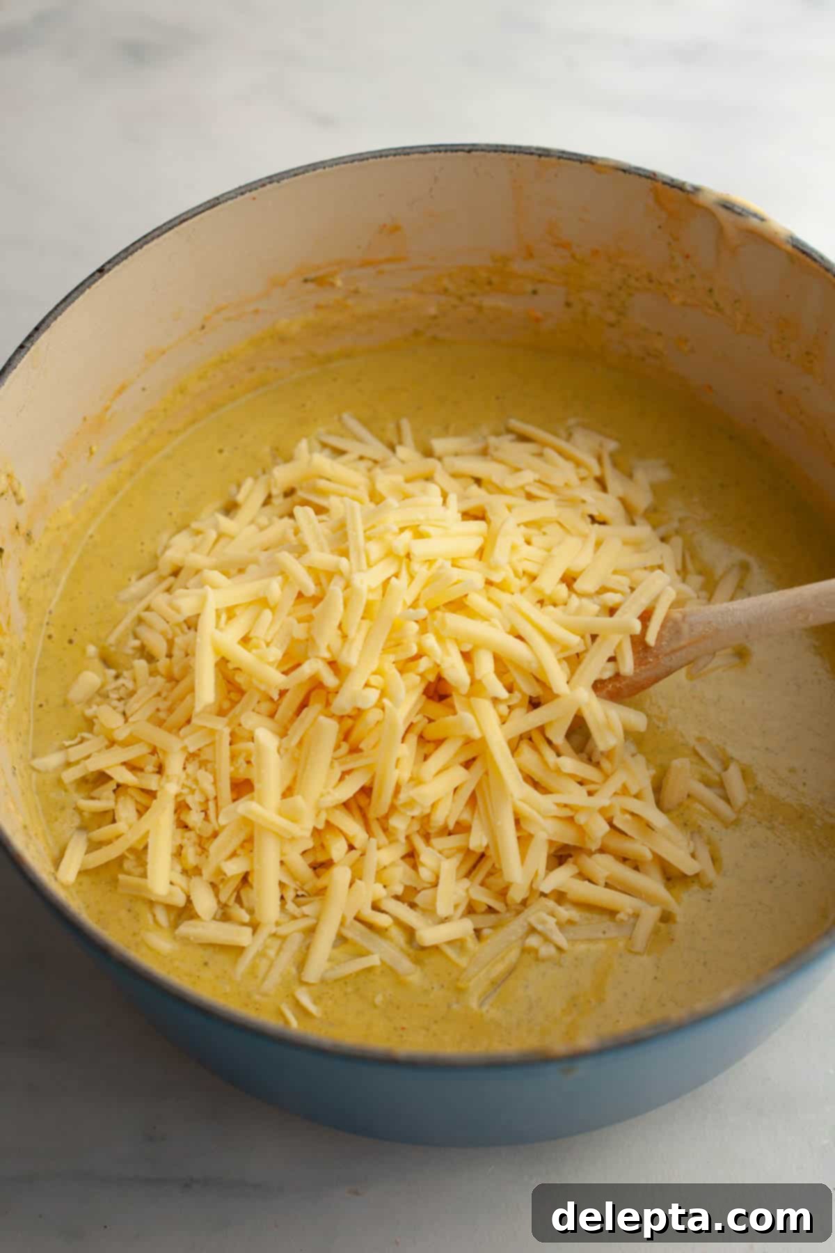 Velvety Chicken and Broccoli Cheddar Soup 10 A large pot of pureed broccoli soup, with a mound of freshly grated cheddar cheese waiting to be stirred in.