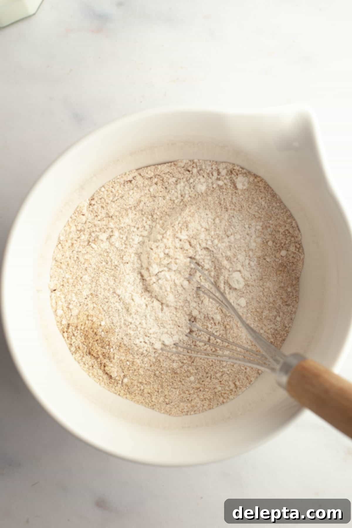Irresistible Brown Butter Cardamom Almond Cake Recipe 7 A large white bowl with whisked flour, almond flour, and cardamom.