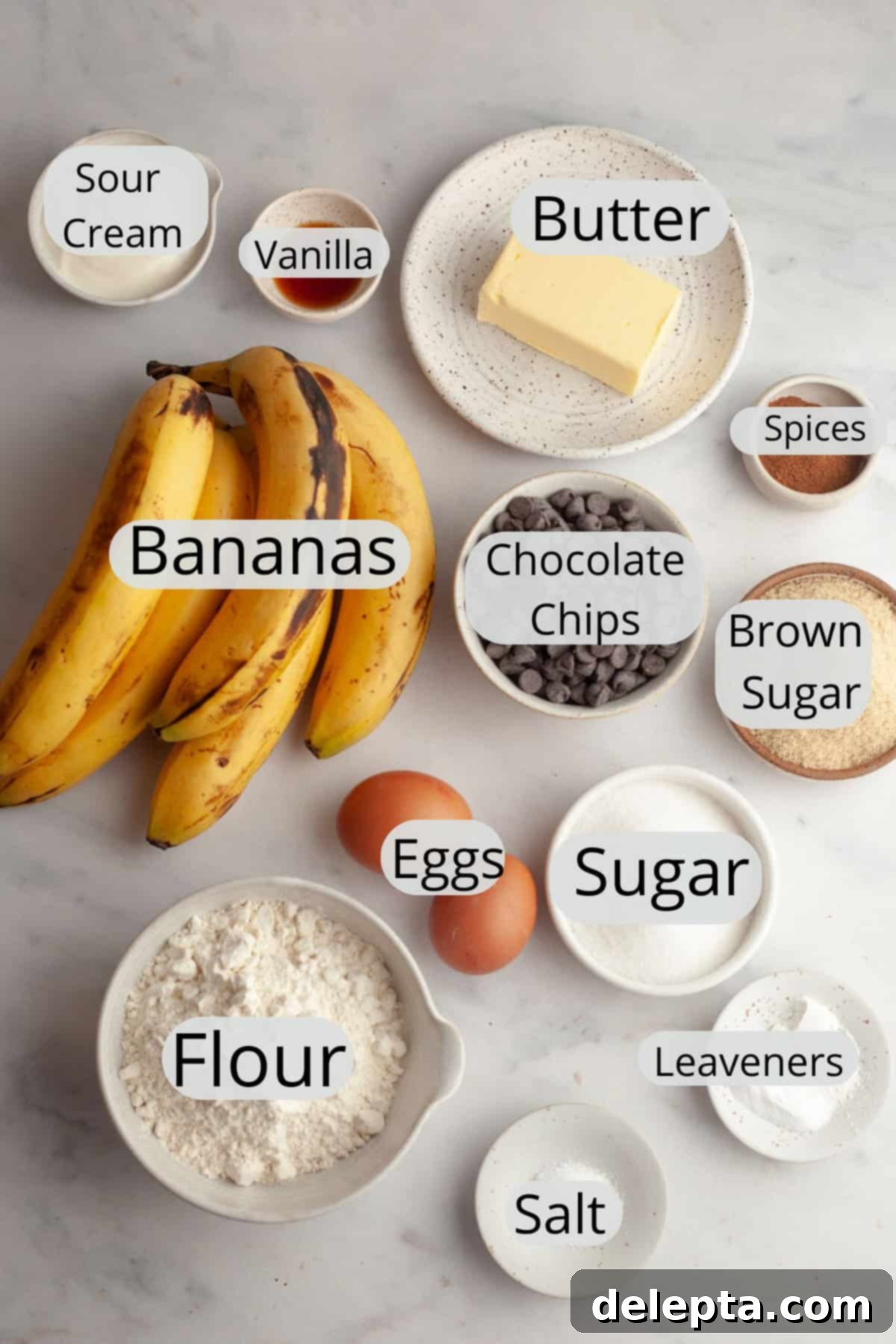 Bakery Style Jumbo Banana Chocolate Chip Muffins 3 All the ingredients needed to make jumbo banana muffins, weighed out into small bowls, including ripe bananas, flour, sugar, and chocolate chips.