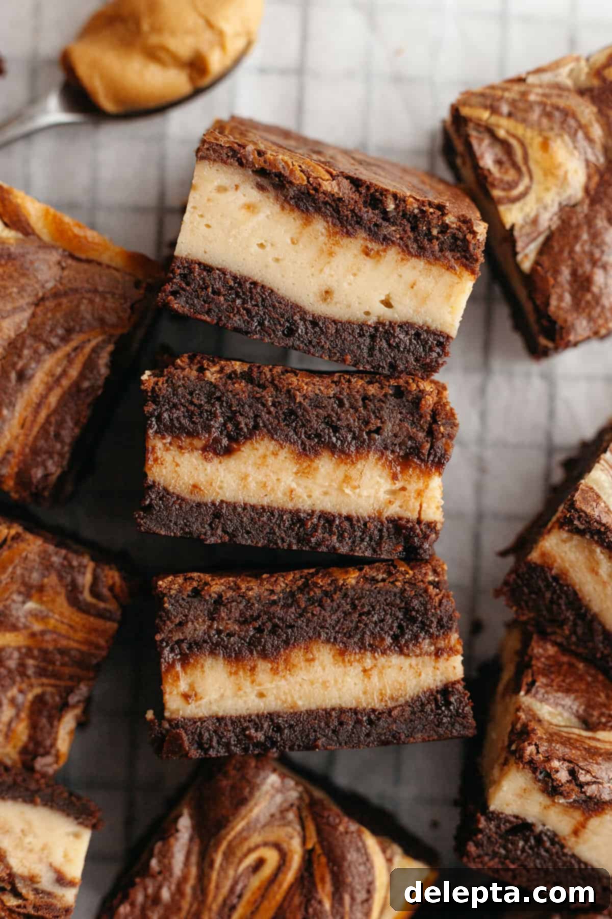 Decadent Peanut Butter Cream Cheese Swirl Brownies 13 Sliced peanut butter cream cheese brownies on parchment paper, showing their perfectly cut edges.