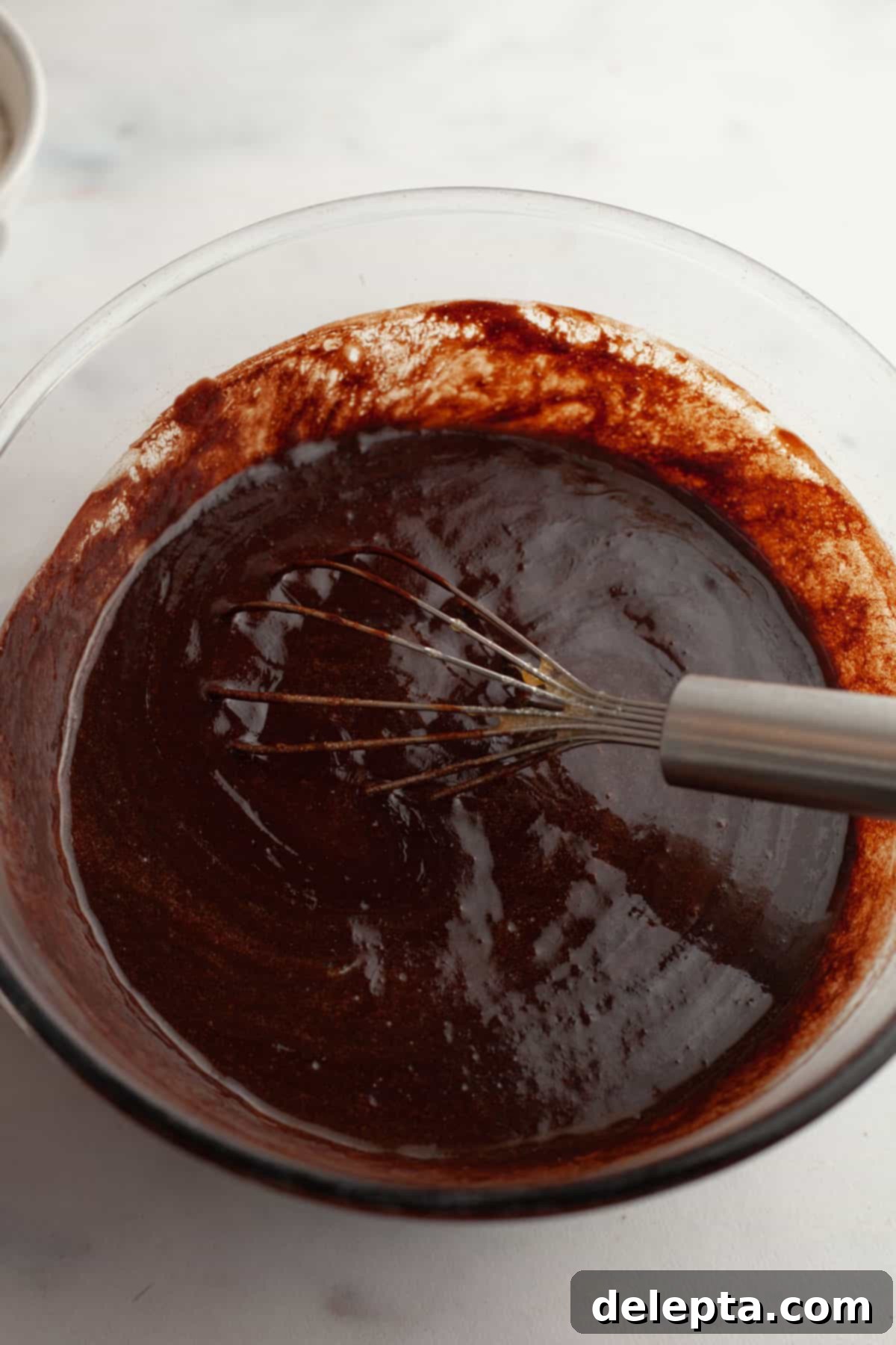 Decadent Peanut Butter Cream Cheese Swirl Brownies 7 A glass bowl with brownie batter in it and a whisk, looking smooth and rich.