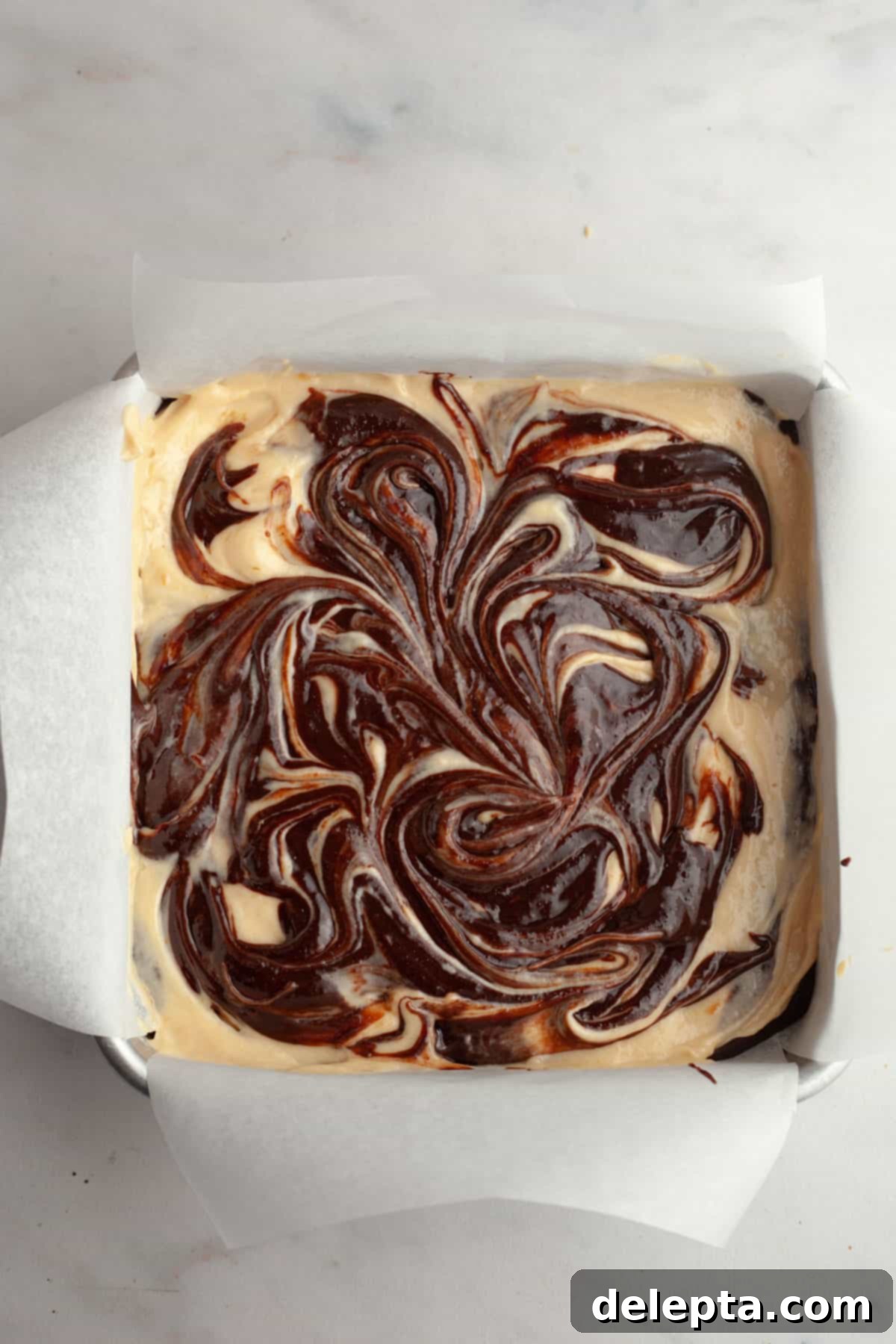 Decadent Peanut Butter Cream Cheese Swirl Brownies 10 Unbaked peanut butter cream cheese brownies in a square pan, showing the beautiful swirls.