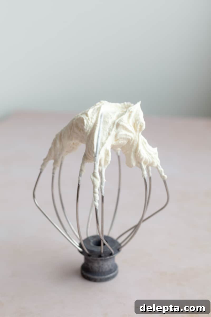 Pistachio-Infused Carrot Cake with Cloud-Like Cream Cheese Frosting 9 A whisk attachment with heavy cream that has been whipped