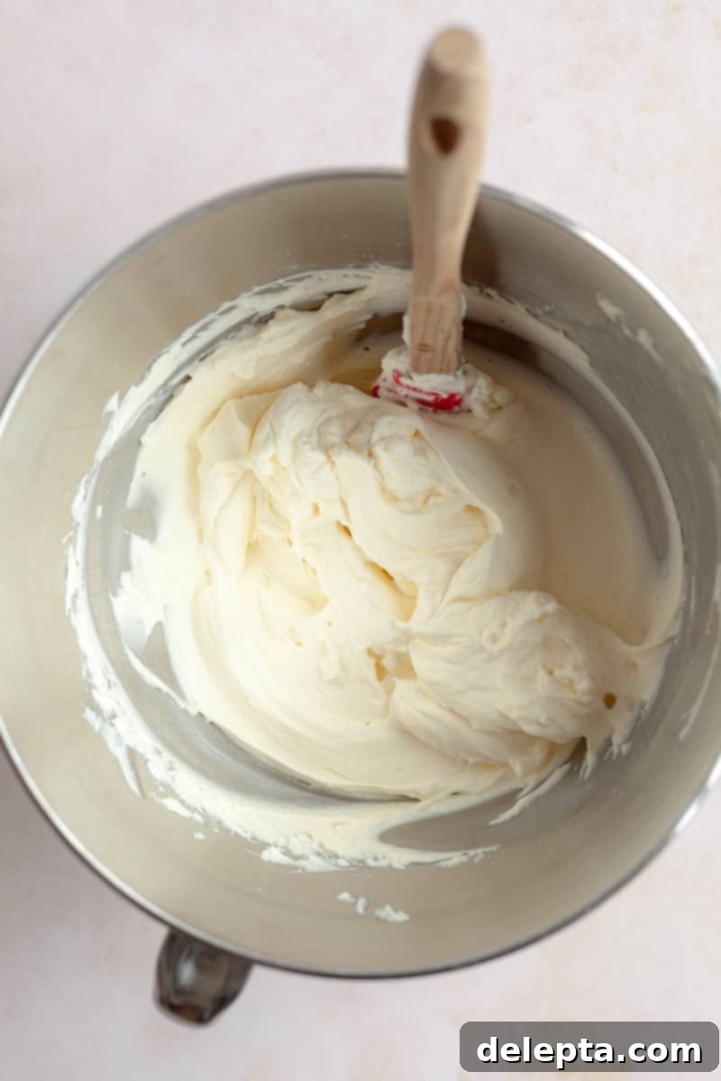 Pistachio-Infused Carrot Cake with Cloud-Like Cream Cheese Frosting 10 Cream cheese frosting in a metal measuring bowl.