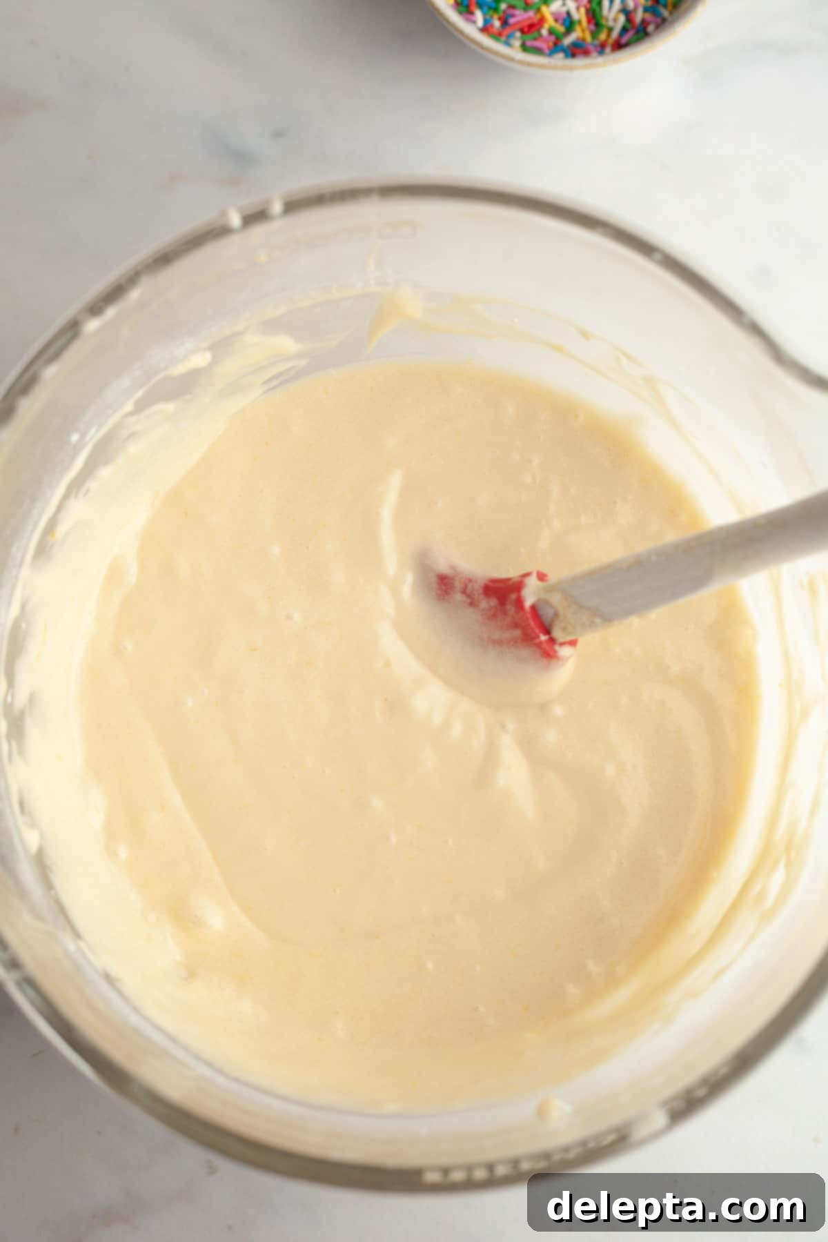 Strawberry Funfetti Fantasy 7 Smooth vanilla cake batter in a large mixing bowl, ready for sprinkles.