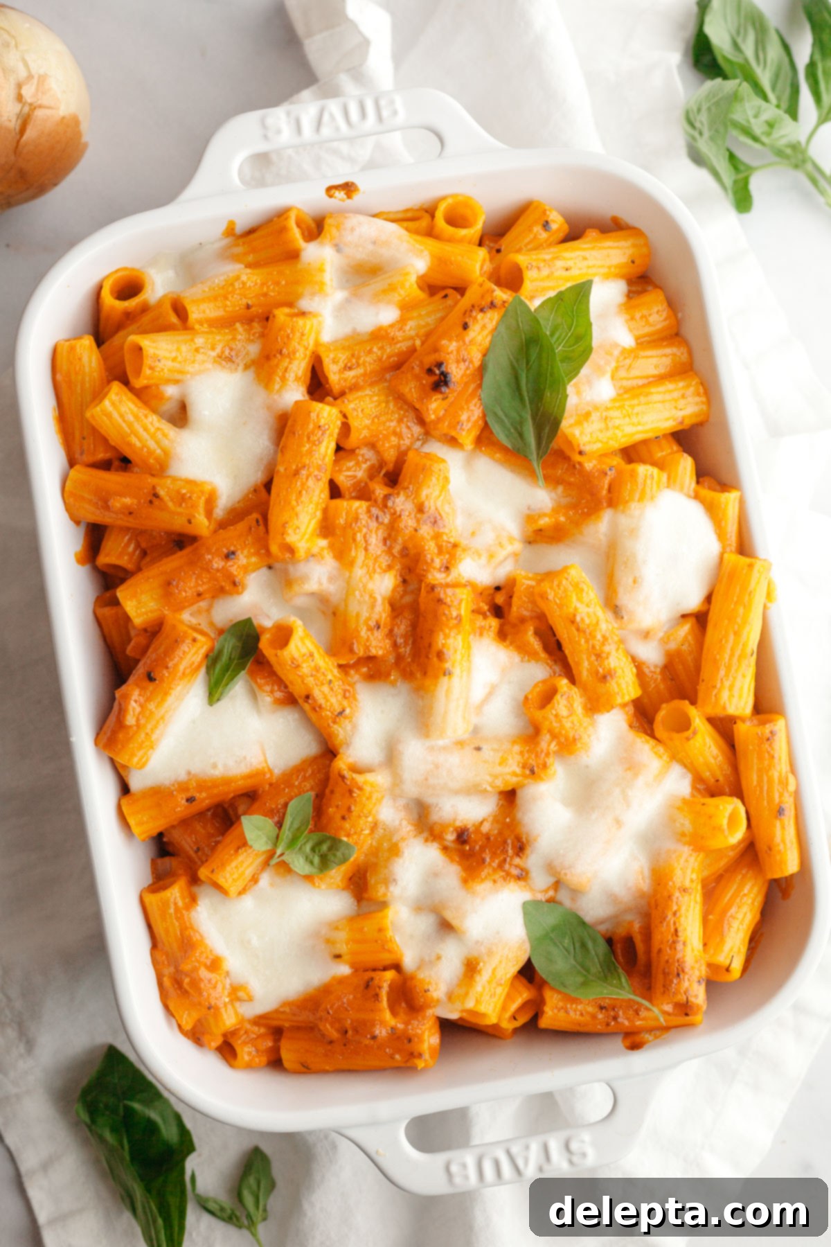 Easy Baked Pasta with Virgin Vodka Sauce 2 Baked vodka pasta in a white dish topped with fresh basil leaves, ready to be served.