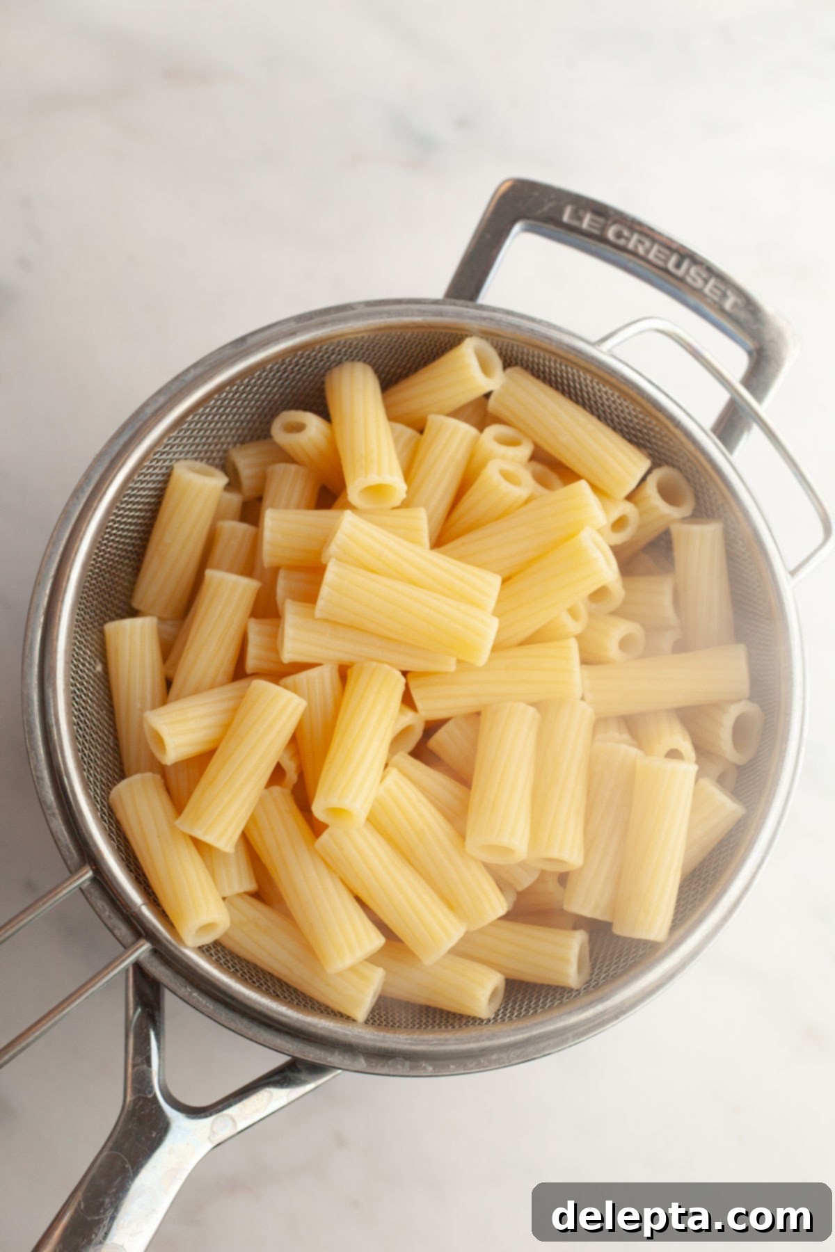 Easy Baked Pasta with Virgin Vodka Sauce 4 Cooked rigatoni pasta draining in a sieve.
