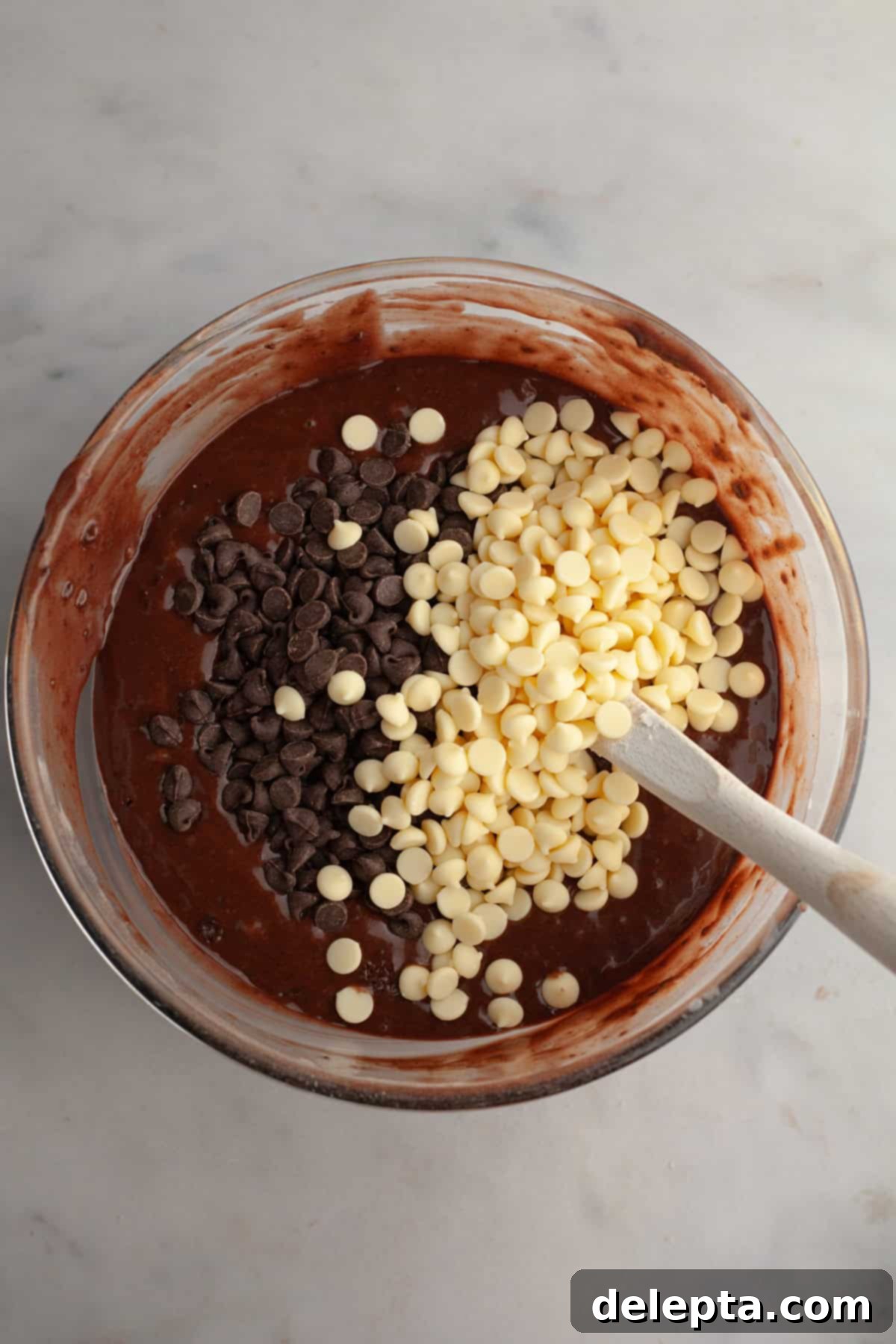 Triple Chocolate Muffins One Bowl Wonder 6 A bowl of chocolate muffin batter generously studded with both white chocolate chips and dark chocolate chips.