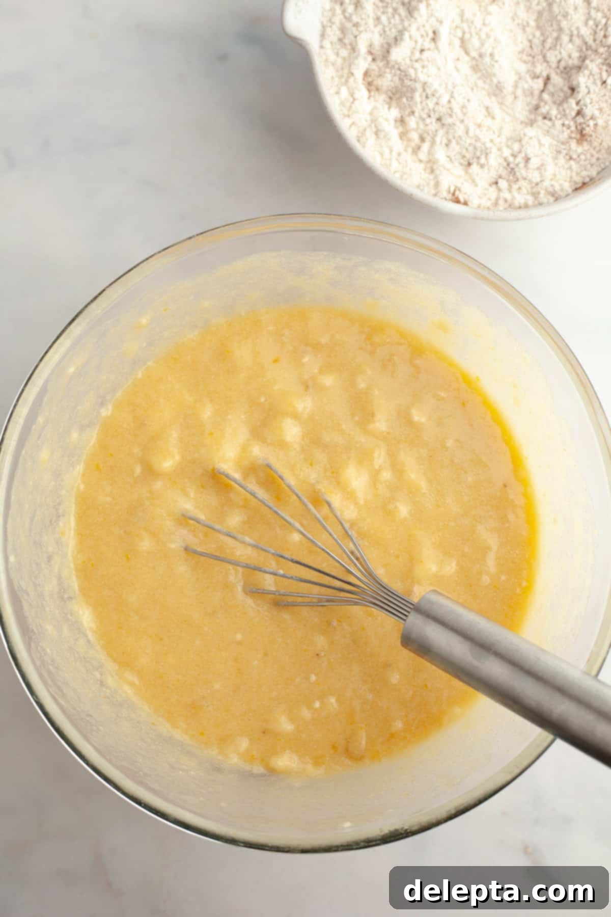 Cinnamon Crumble Banana Muffins 5 Smooth, well-combined banana muffin batter in a mixing bowl, showcasing its rich texture.