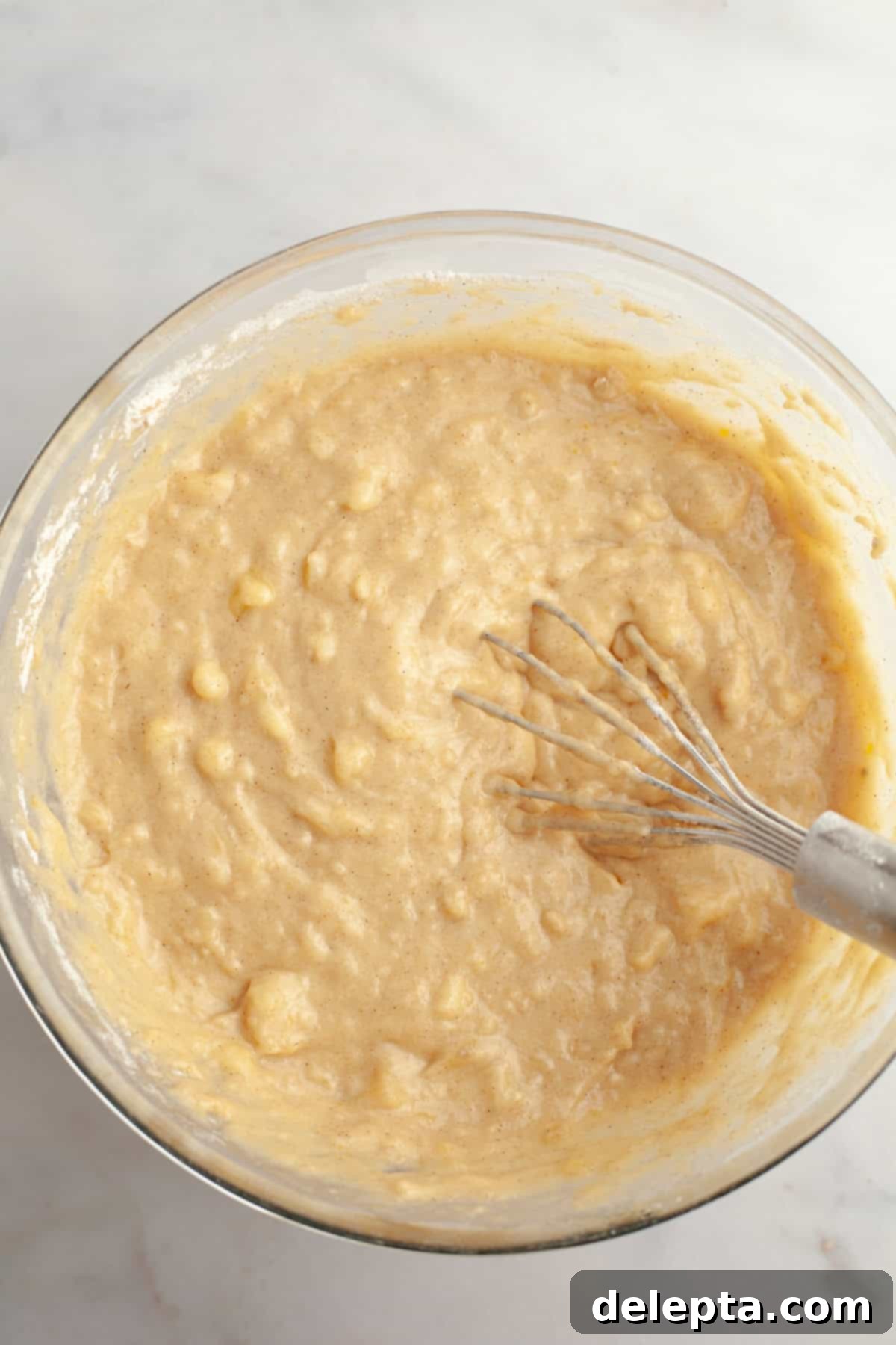 Cinnamon Crumble Banana Muffins 6 Gently mixed banana muffin batter in a bowl, ready for the next step of preparation.