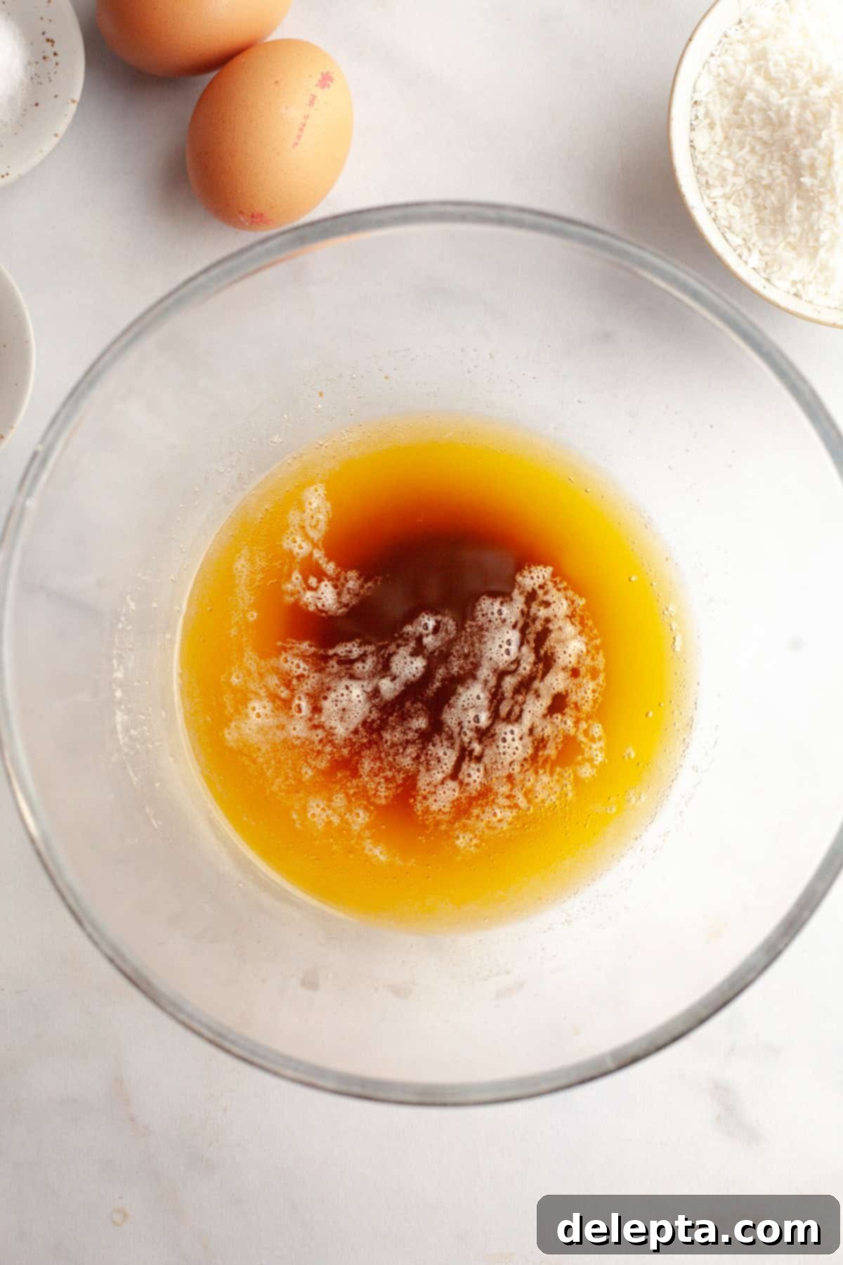 Brown Butter Oatmeal Cookies with Chocolate Chips and Coconut 4 Brown butter in a clear glass bowl, showcasing its golden-brown color and nutty milk solids at the bottom.
