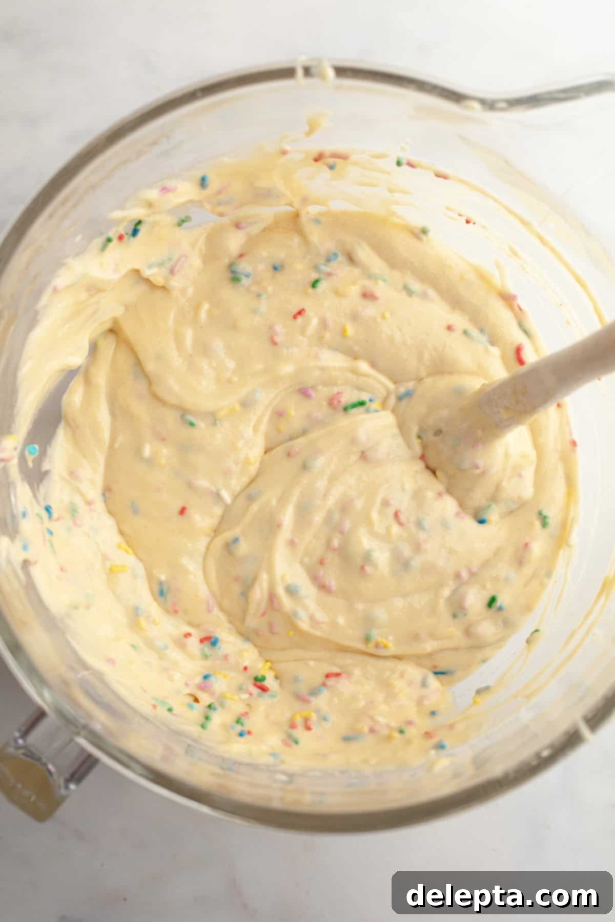 Simply Delicious Funfetti Oreo Cake with Dreamy Oreo Frosting 6 Vibrant funfetti cake batter, studded with colorful sprinkles, in a large mixing bowl.