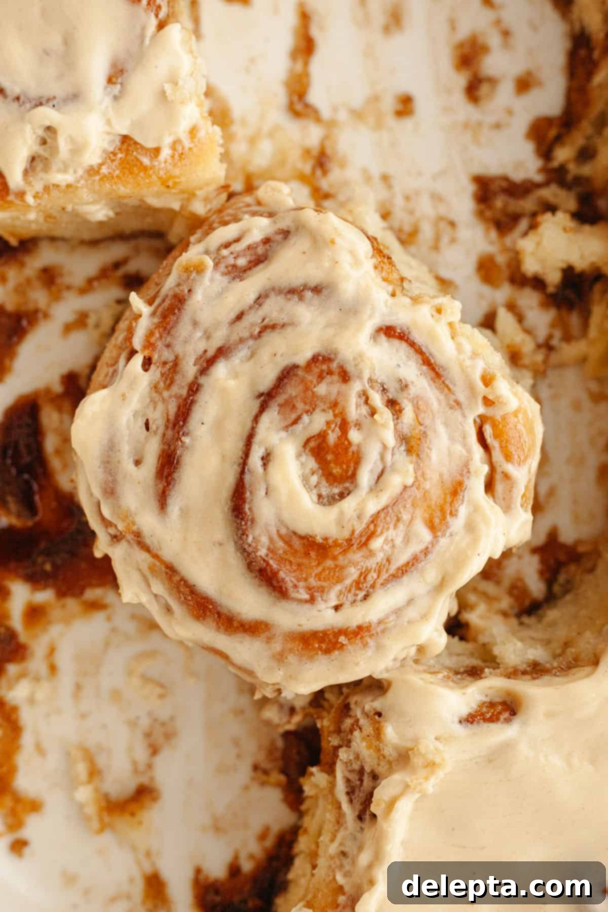 Maple Espresso Cinnamon Swirls 12 A cinnamon coffee roll with maple espresso icing in a dish.