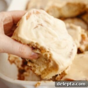 Maple Espresso Cinnamon Swirls 14 A hand grabbing a cinnamon coffee roll.