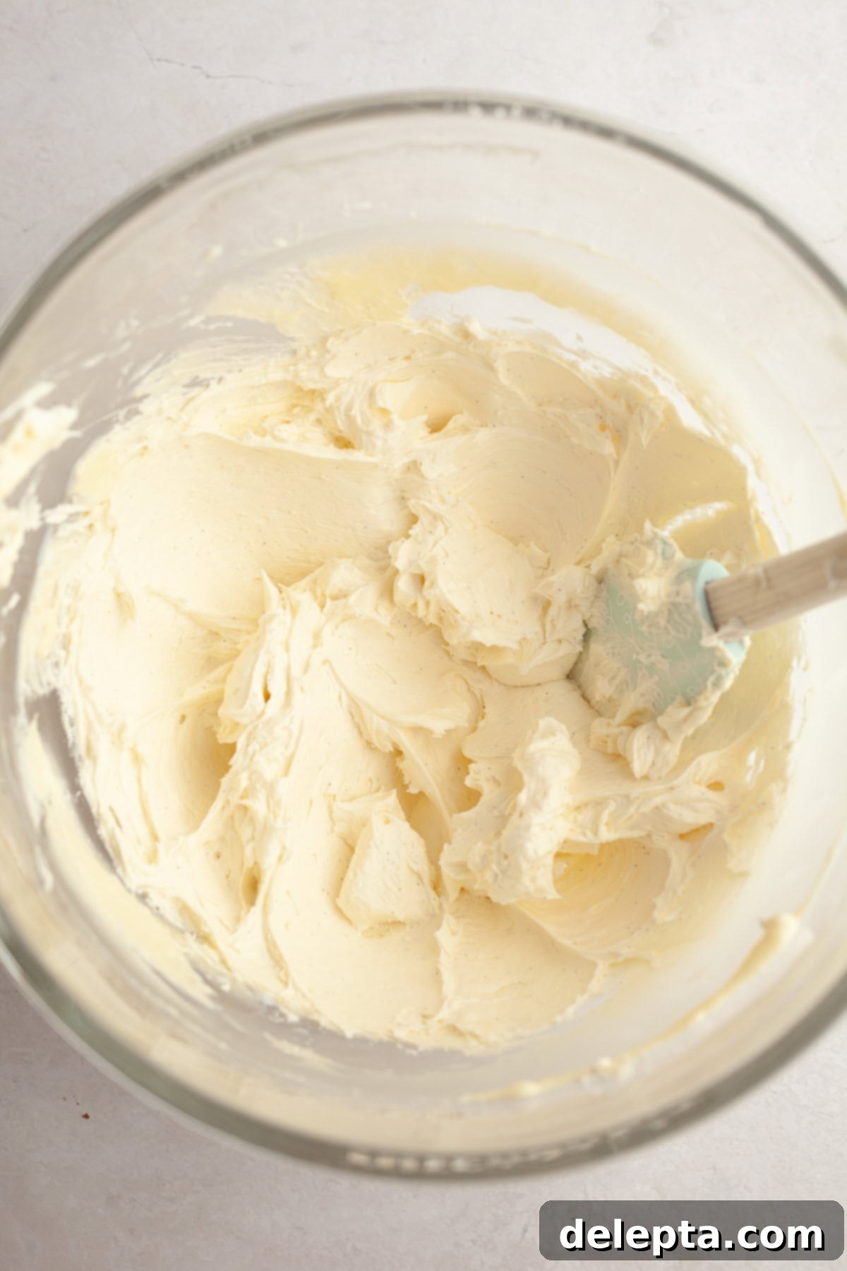 Pure Vanilla Bean Bliss Cupcakes 8 A generous amount of creamy vanilla bean frosting, flecked with vanilla seeds, in a large glass bowl, ready for piping.