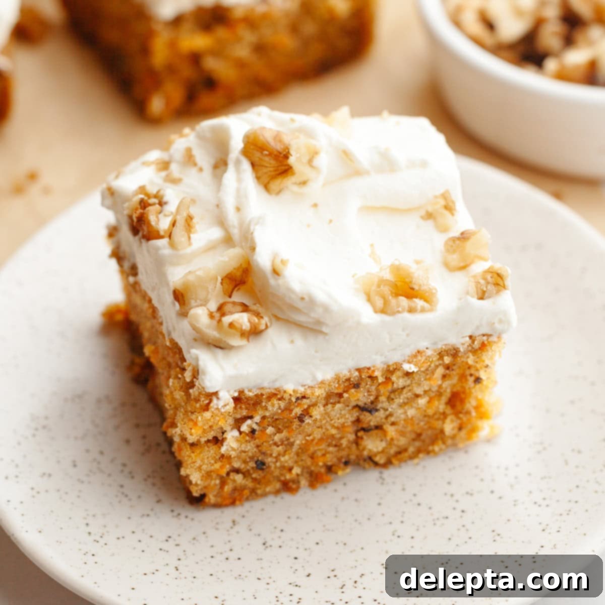 Butter-Free Mini Carrot Cake with Dreamy Cream Cheese Frosting 2 A slice of mini carrot cake with cream cheese frosting and chopped walnuts.