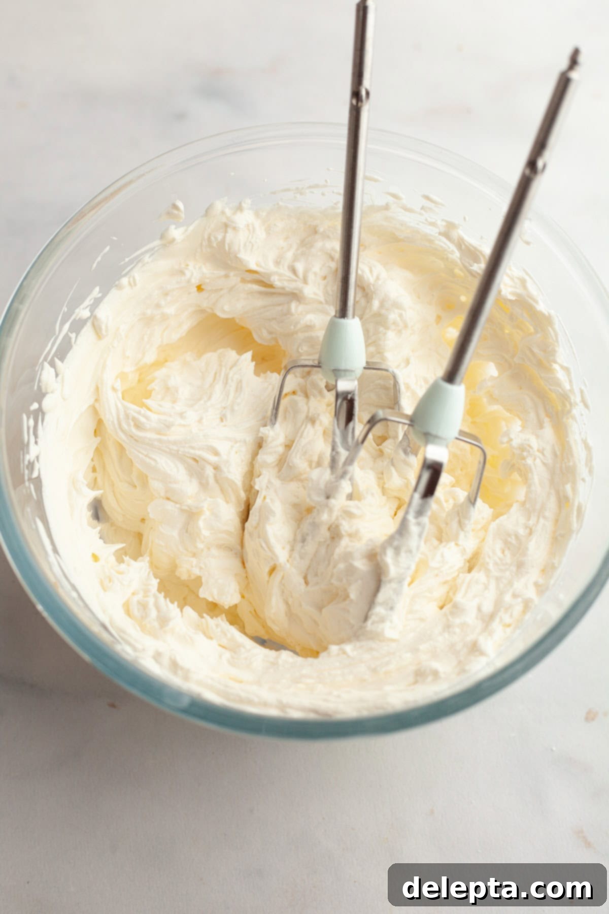 Butter-Free Mini Carrot Cake with Dreamy Cream Cheese Frosting 7 Cream cheese frosting in a glass bowl.