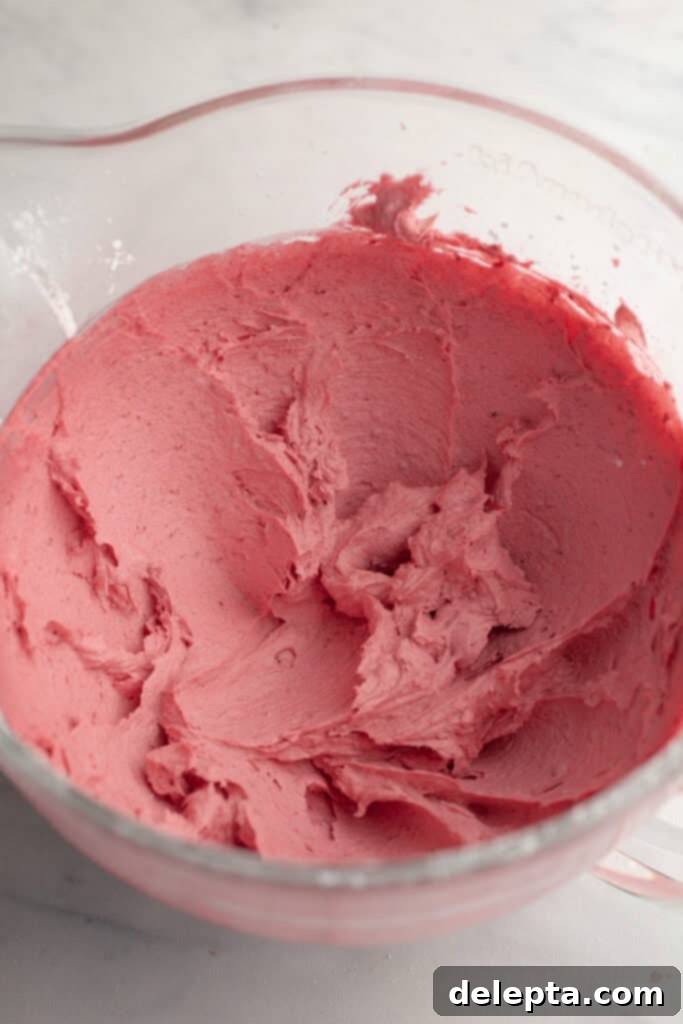 Raspberry Dream Buttercream 5 Vibrantly pink frosting in a large glass bowl, ready to be used.