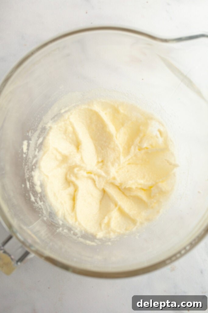 Decadent Raspberry White Chocolate Ganache Cupcakes 4 A large glass mixing bowl with creamed butter and sugar in it.