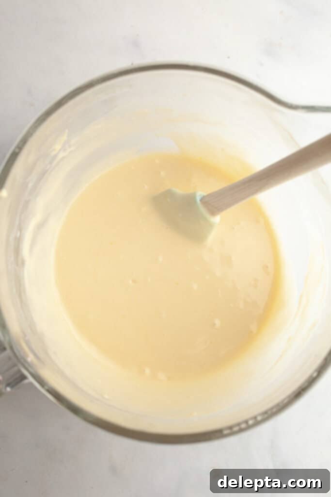 Decadent Raspberry White Chocolate Ganache Cupcakes 6 A large glass mixing bowl with vanilla cupcake batter.