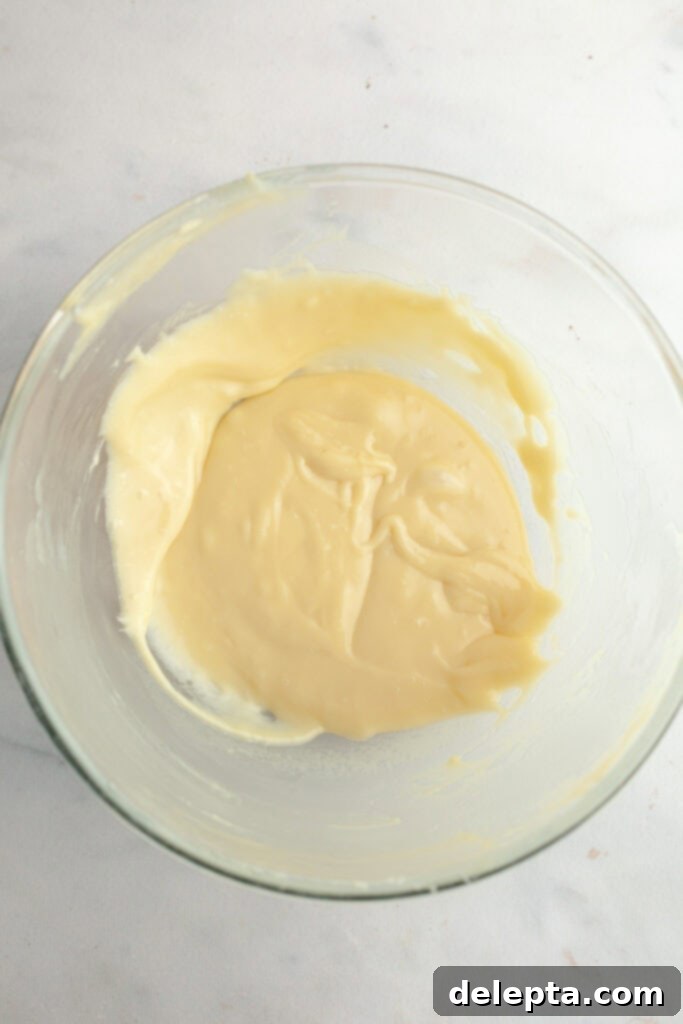 Decadent Raspberry White Chocolate Ganache Cupcakes 9 White chocolate ganache in a bowl.